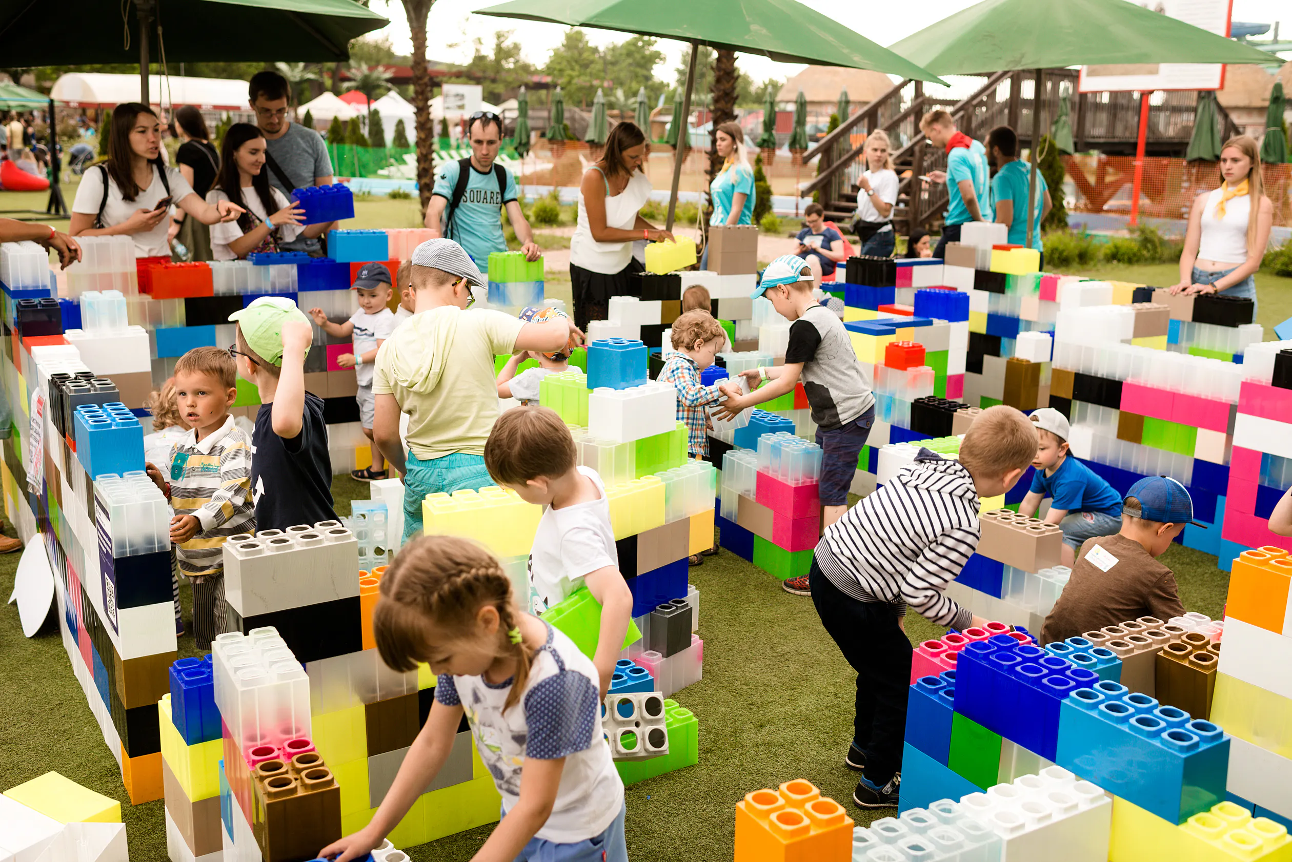 Children building walls from giant plastic construction blocks in the EPAM Family Day play zone