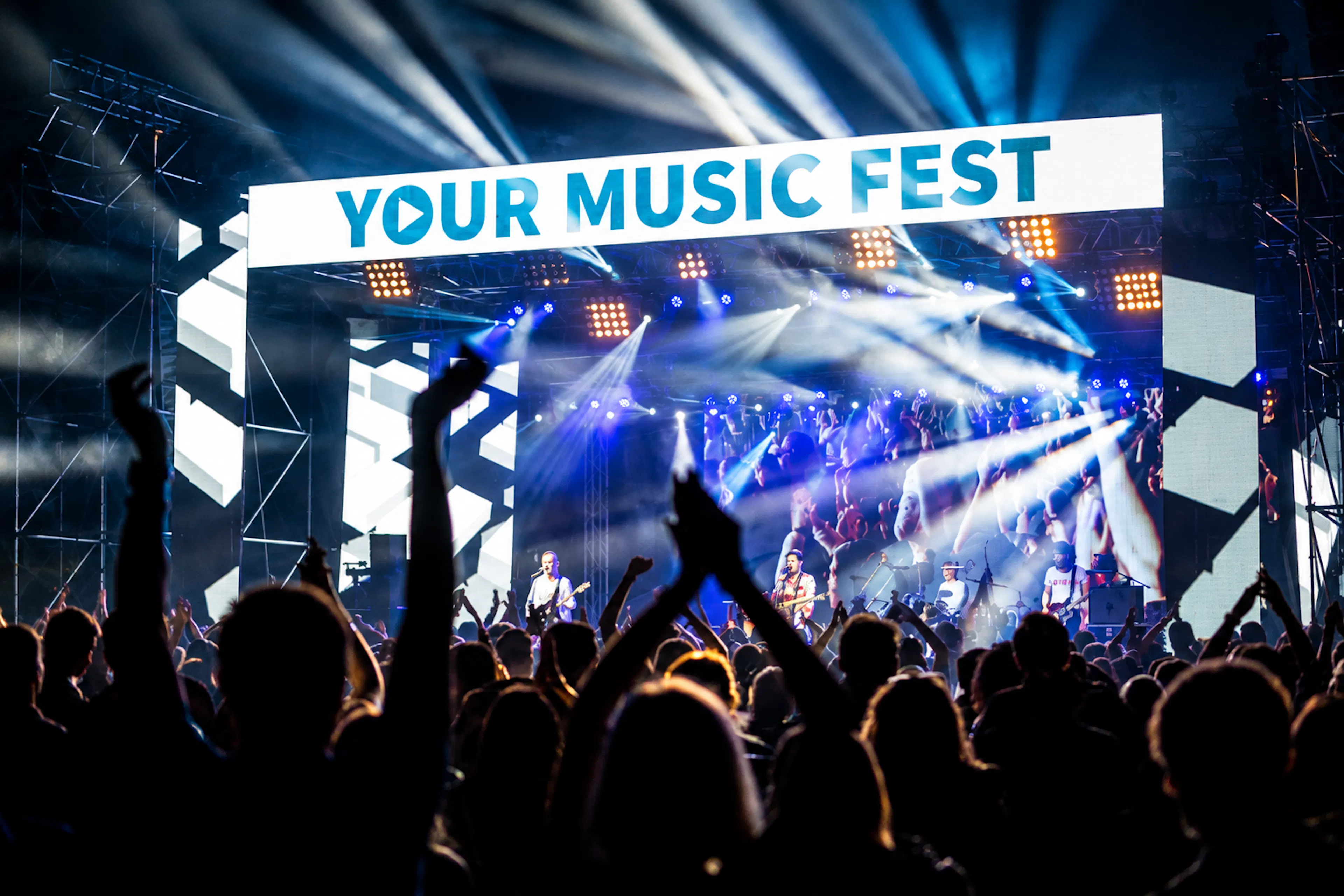 Publiczność bawi się przed główną sceną Your Music Fest w niebieskim świetle koncertowym