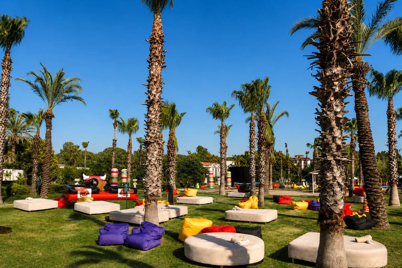 Palm garden lounge zone with daybeds, bean bags and a rodeo bull at the Young Fest resort