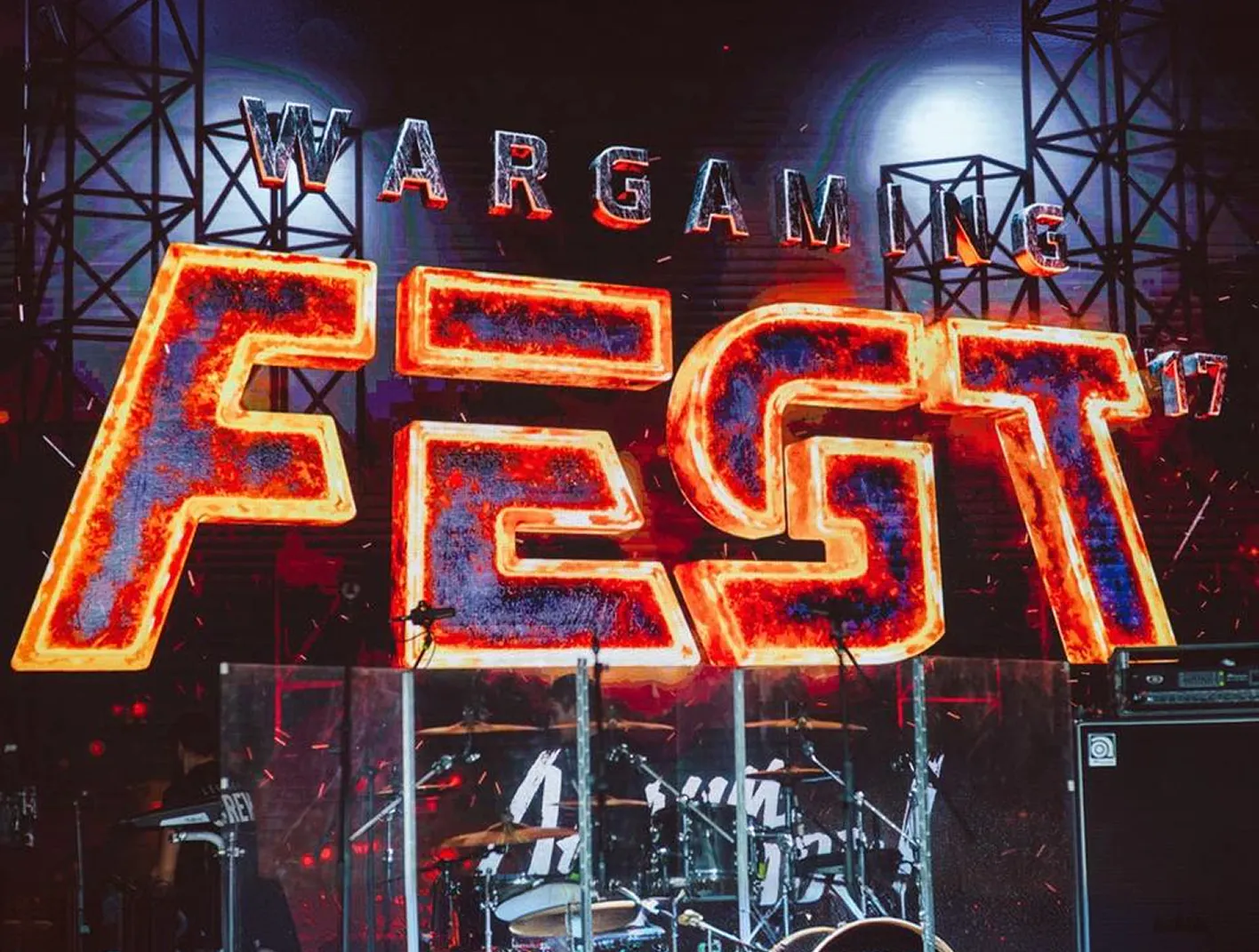 Fiery Wargaming Fest logo on the stage LED wall above a drum kit behind a clear drum shield