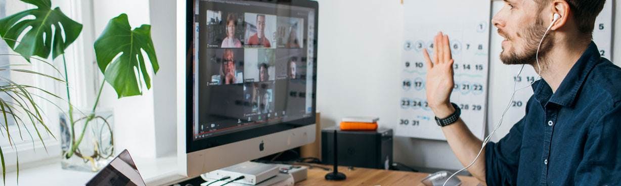 Man at home on computer speaking to colleagues on a video call