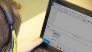 Student, wearing headphones using EquatIO on a laptop