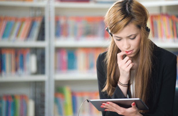 Young woman studying on tablet