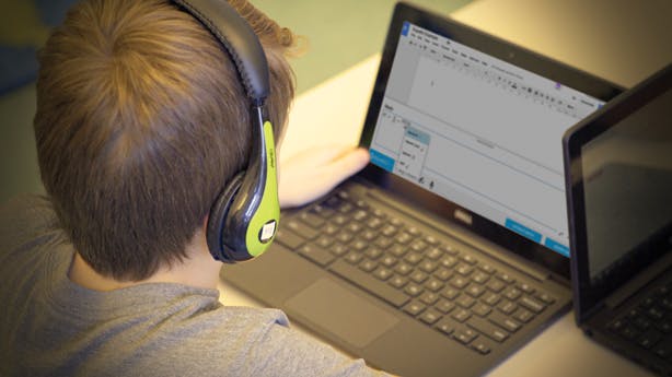 Boy with black and green headphones using EquatIO on a laptop