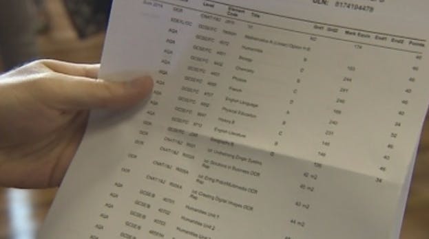 School grades results sheet being held in someone's hand