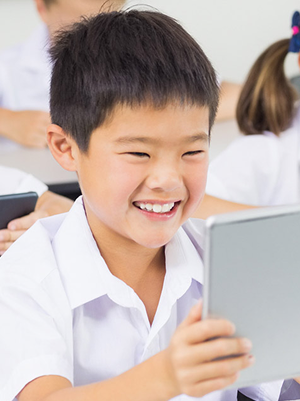 Primary age student, using a tablet in a classroom