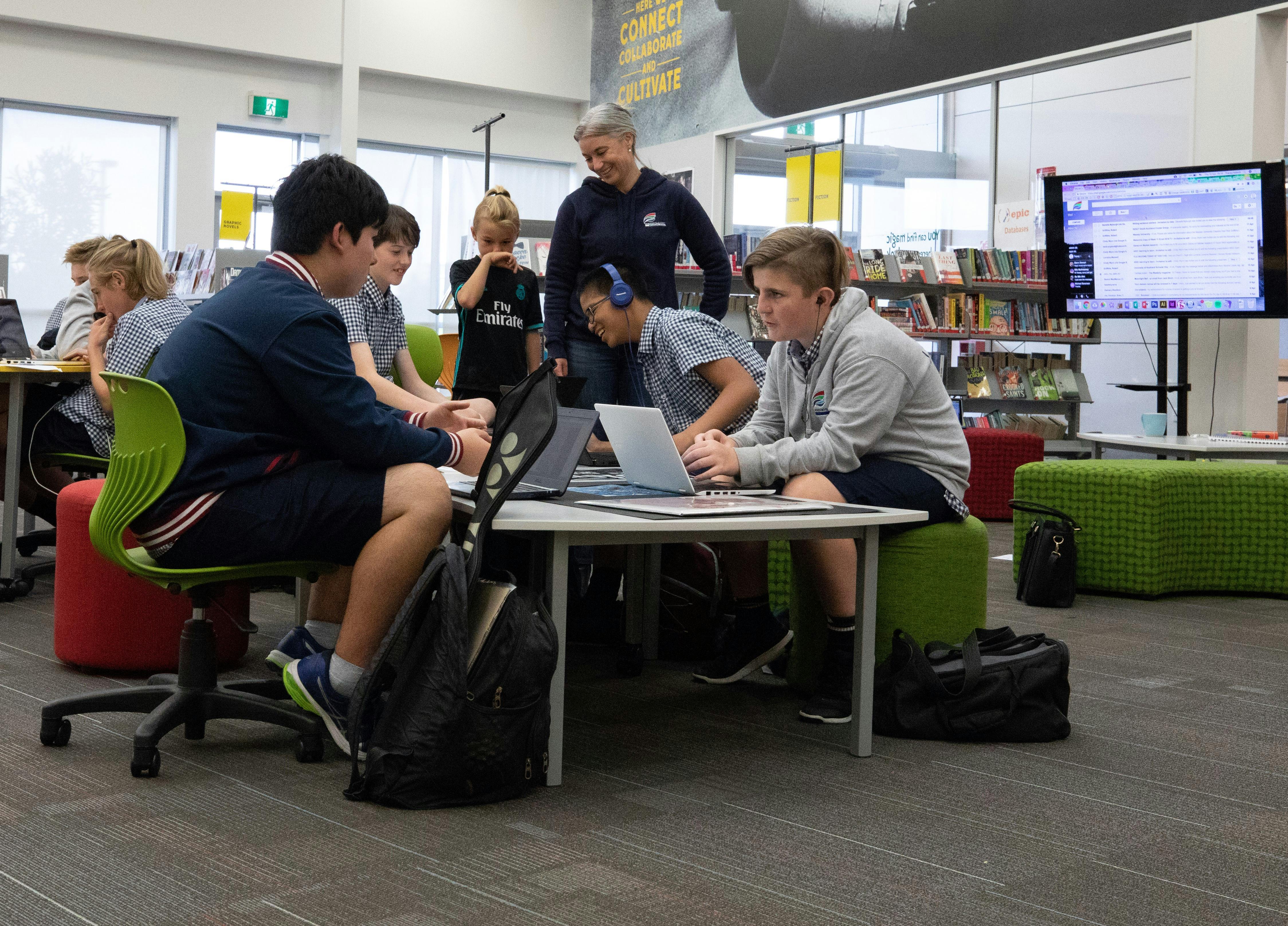 A teacher and her students working collaboratively on their devices at Hobsonville Point Secondary School