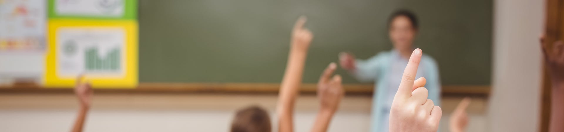 Children with their hands up in class