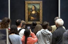 people taking picture of Mona Lisa in the museum 