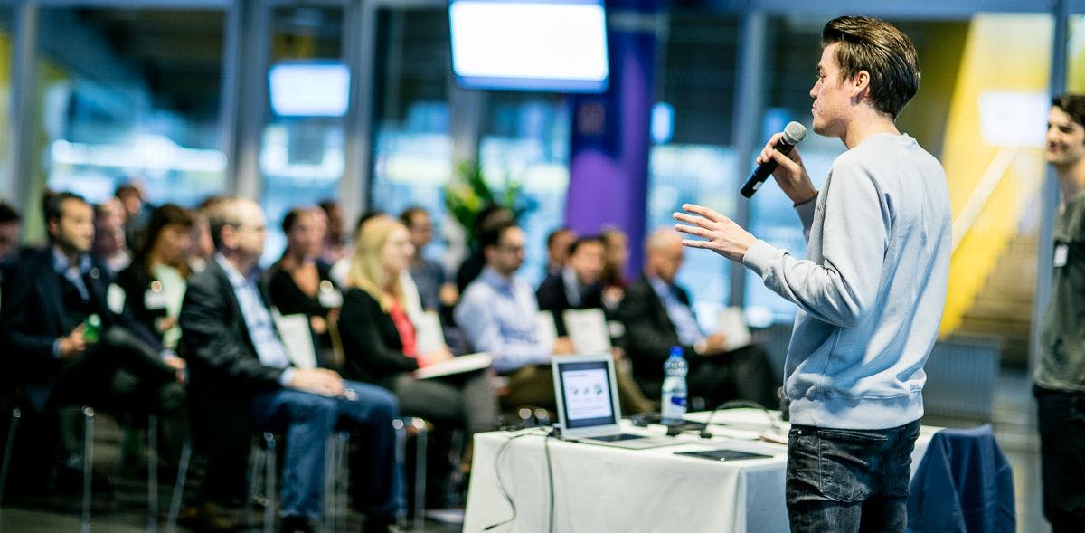 a founder is giving a pitch in front of the crowd 