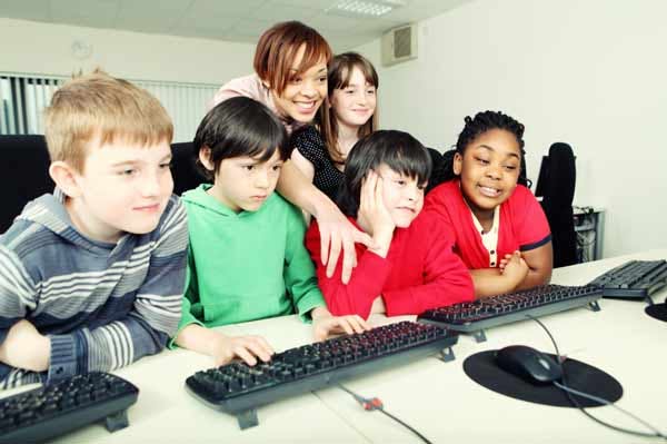 a group of kids is learning to code on computers