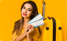mulher branca segurando duas passagens de avião. fundo amarelo e perto dela tem uma mala amarela.