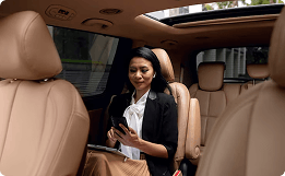 mulher dentro de um carro de luxo olhando para o celular