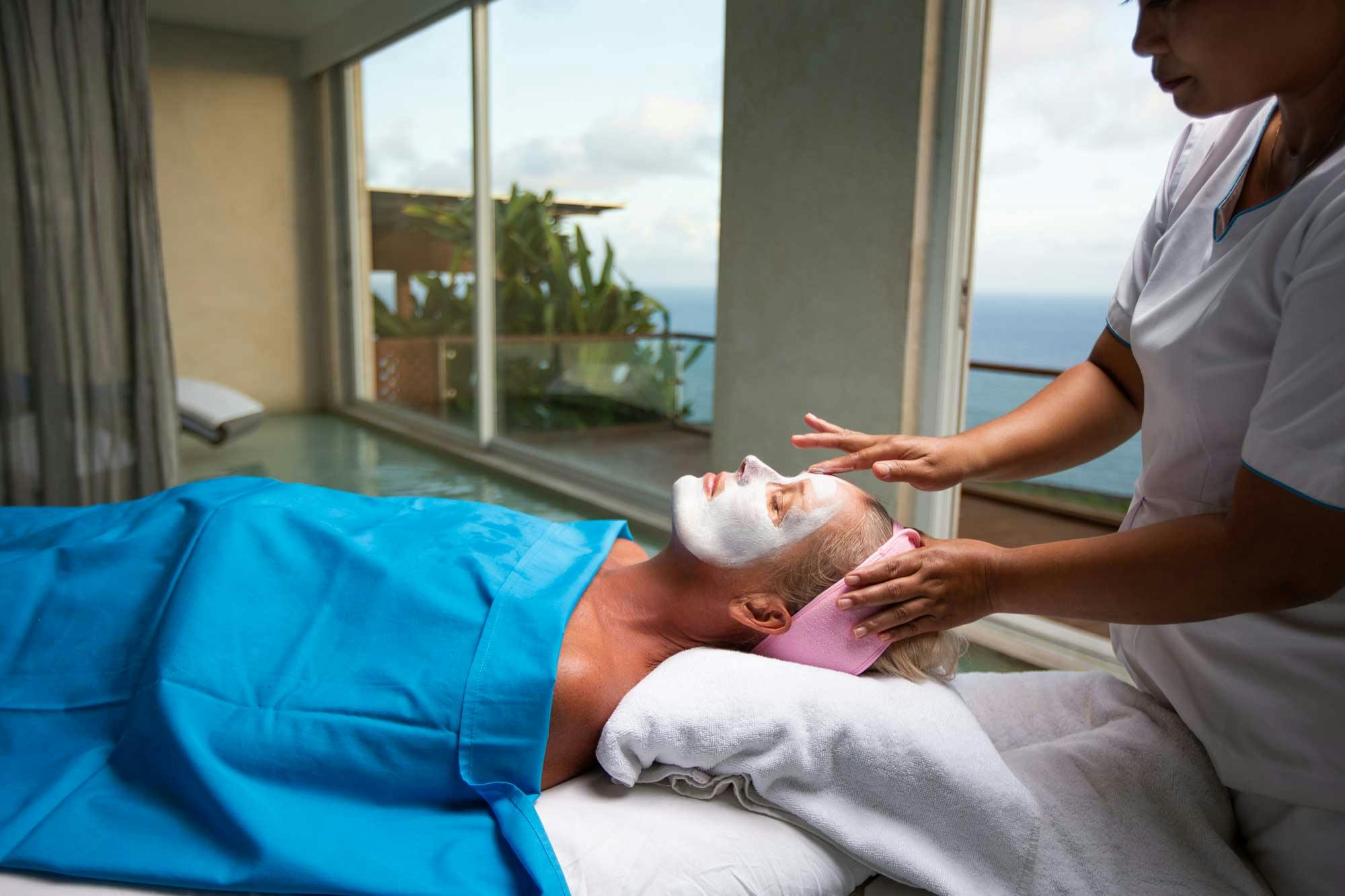 Woman getting a facial in luxurious spa in Uluwatu Bali, with ocean views