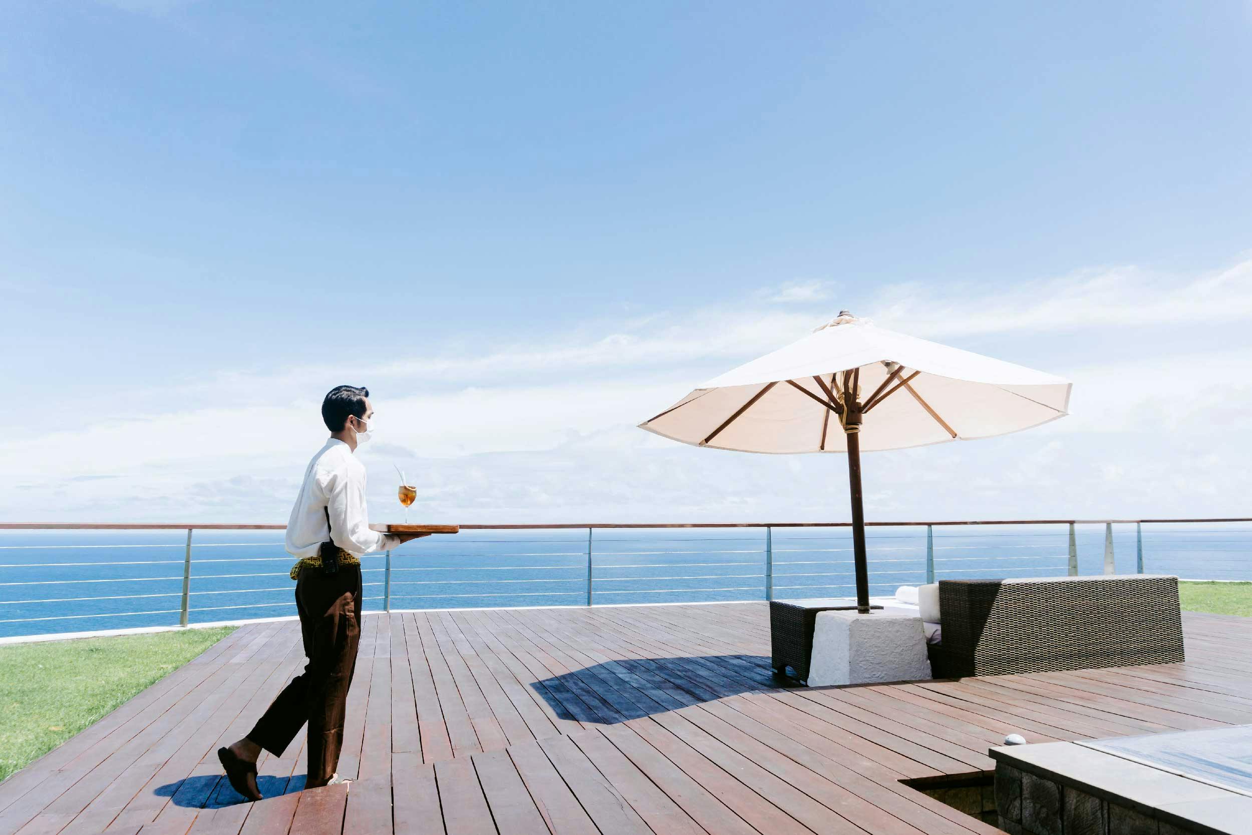 butler walking down the patio of a luxurious villa in Bali