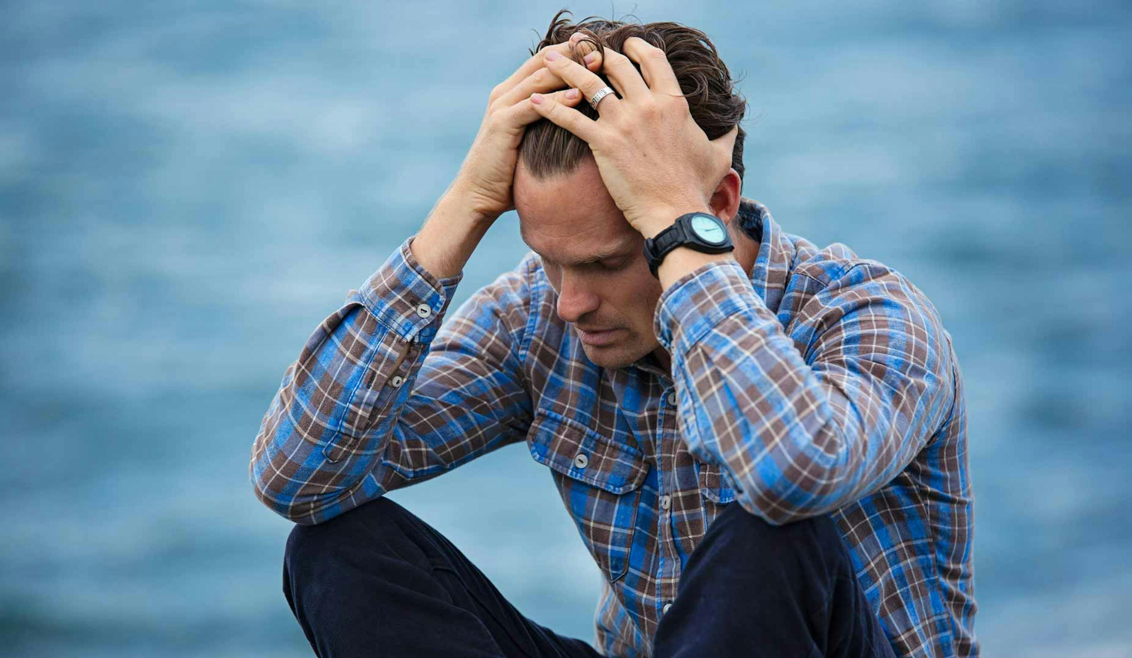 man with hands on head