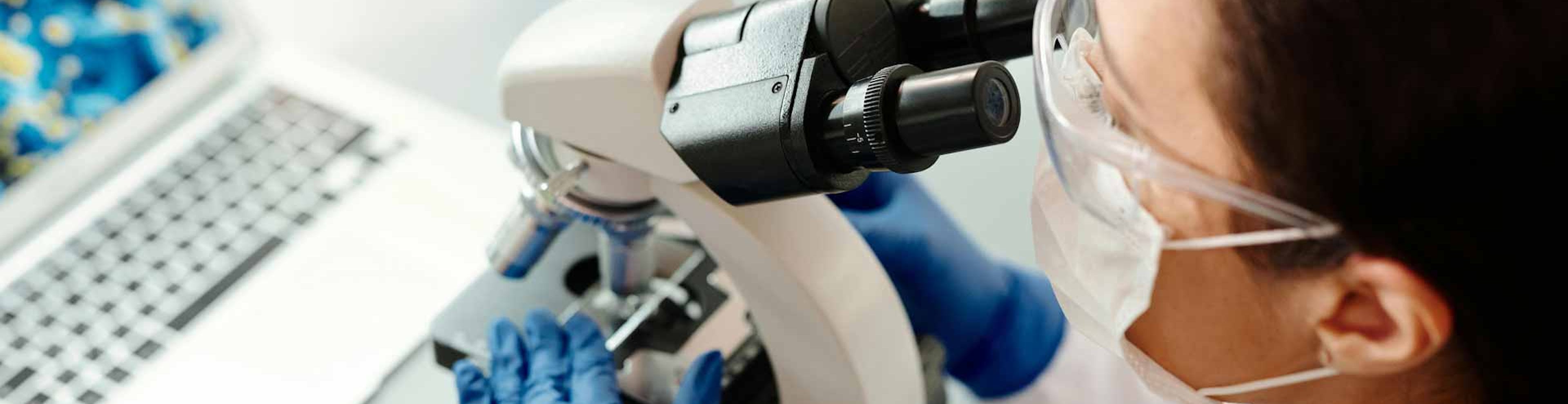 woman looking through microscope