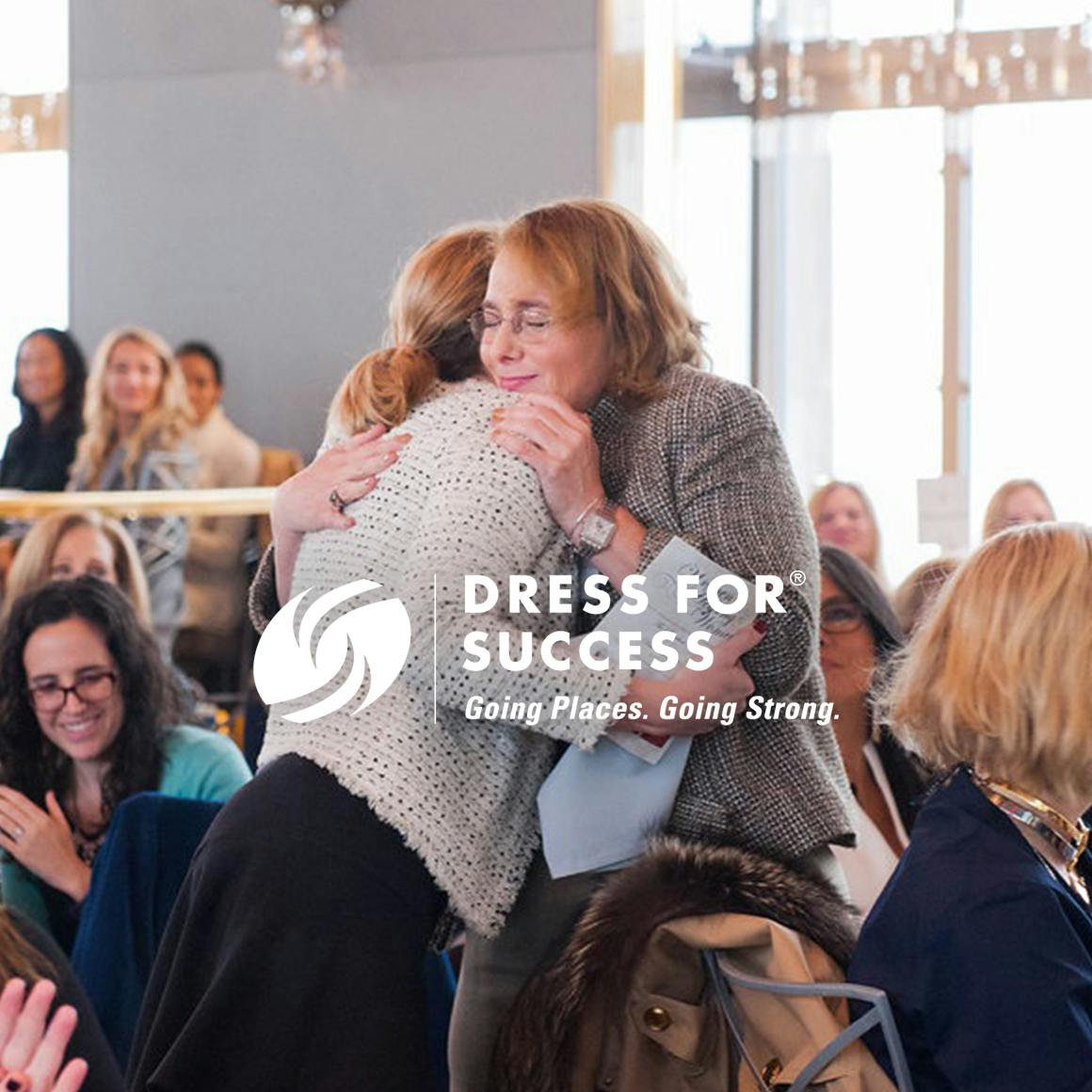 Photo of two women hugging overlaid with theDress for Success logo and motto: Going places, going strong