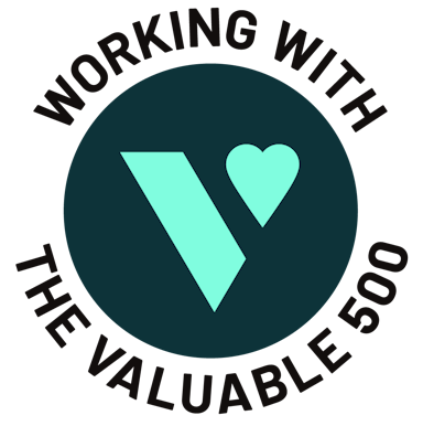 A dark teal circle, with a bright teal logo of the Valuable 500 inside it is shown. Around the circle black text reads ‘Working with The Valuable 500."