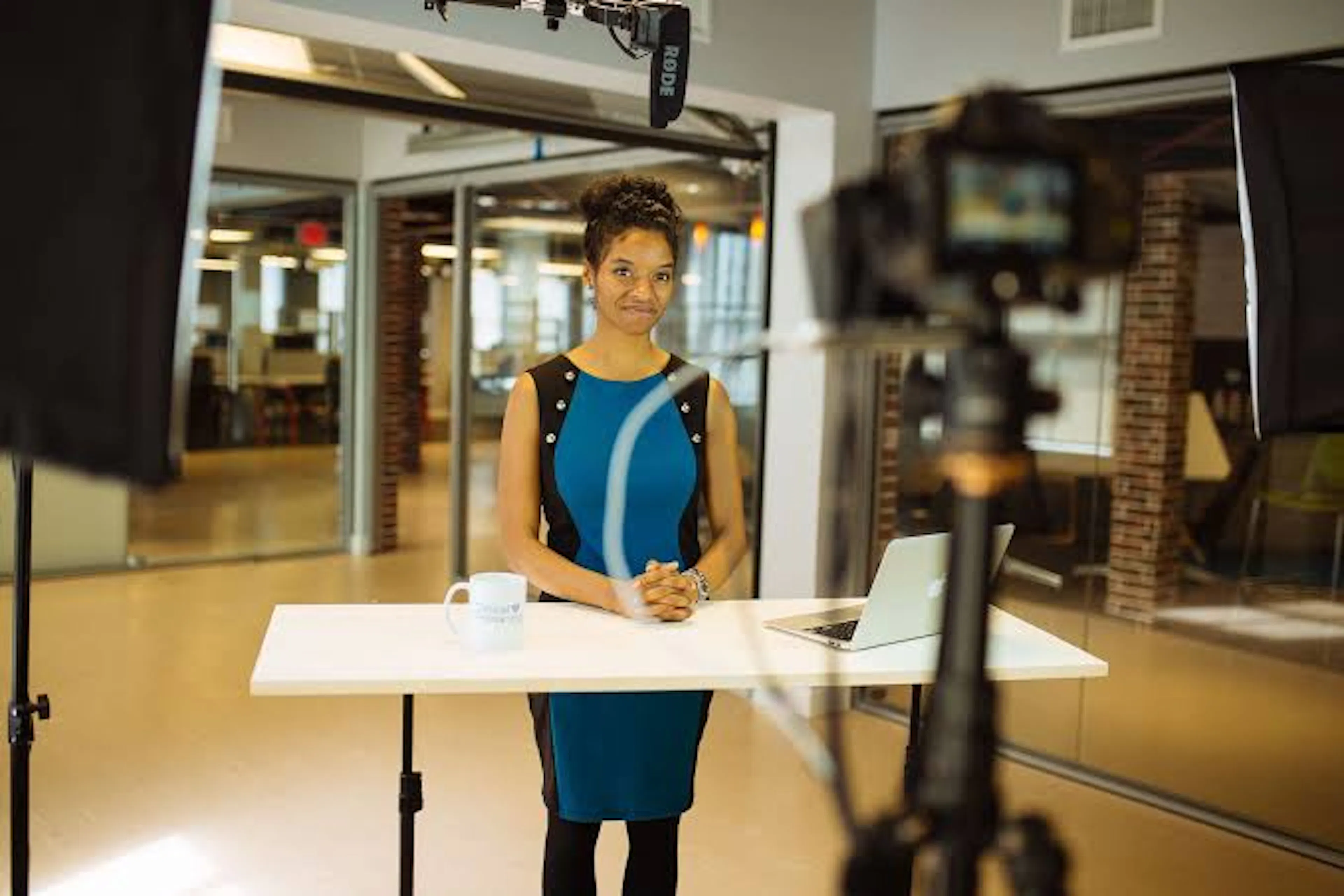 jourdan smiling standing behind table in studio recording trainings