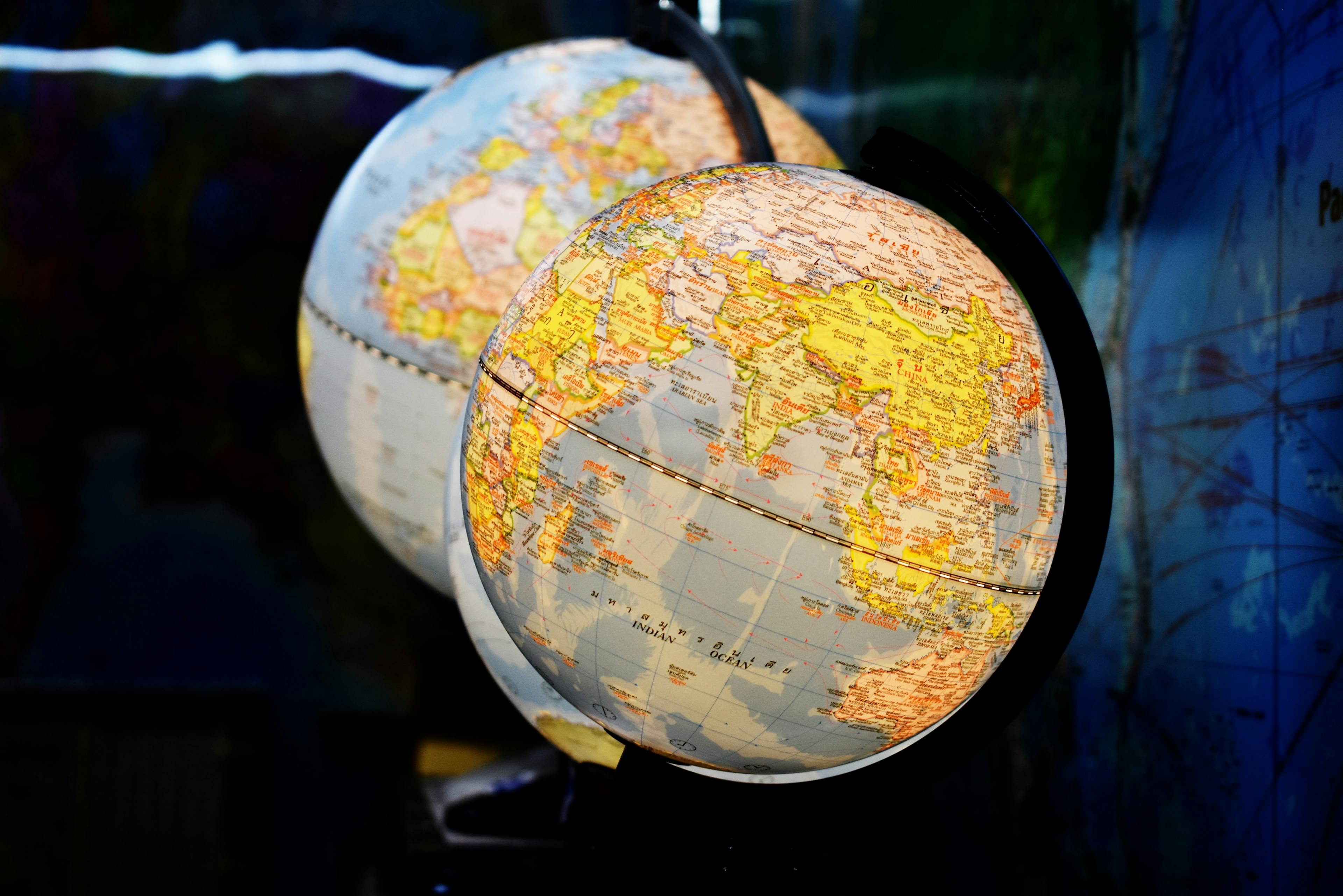 two desk globes next to each other.