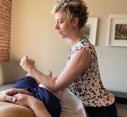 Jennifer Lyons massaging a male's leg