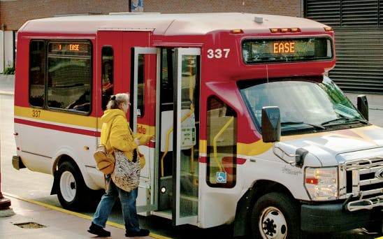 Image of CyRide bus with a passenger walking on to board. 