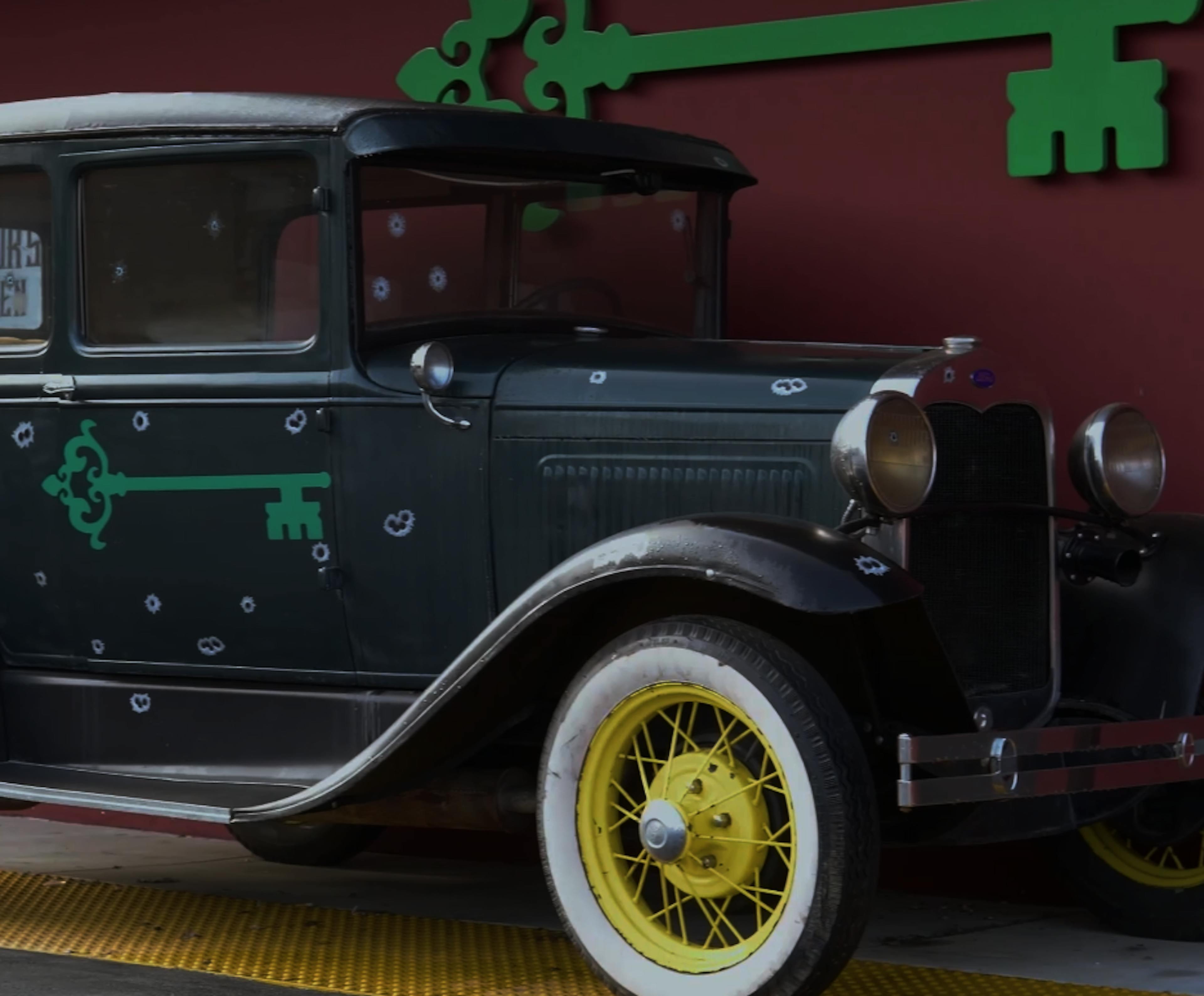 Image of the front door of the syndicate woodland hills classic car with bullet holes and syndicate key logo