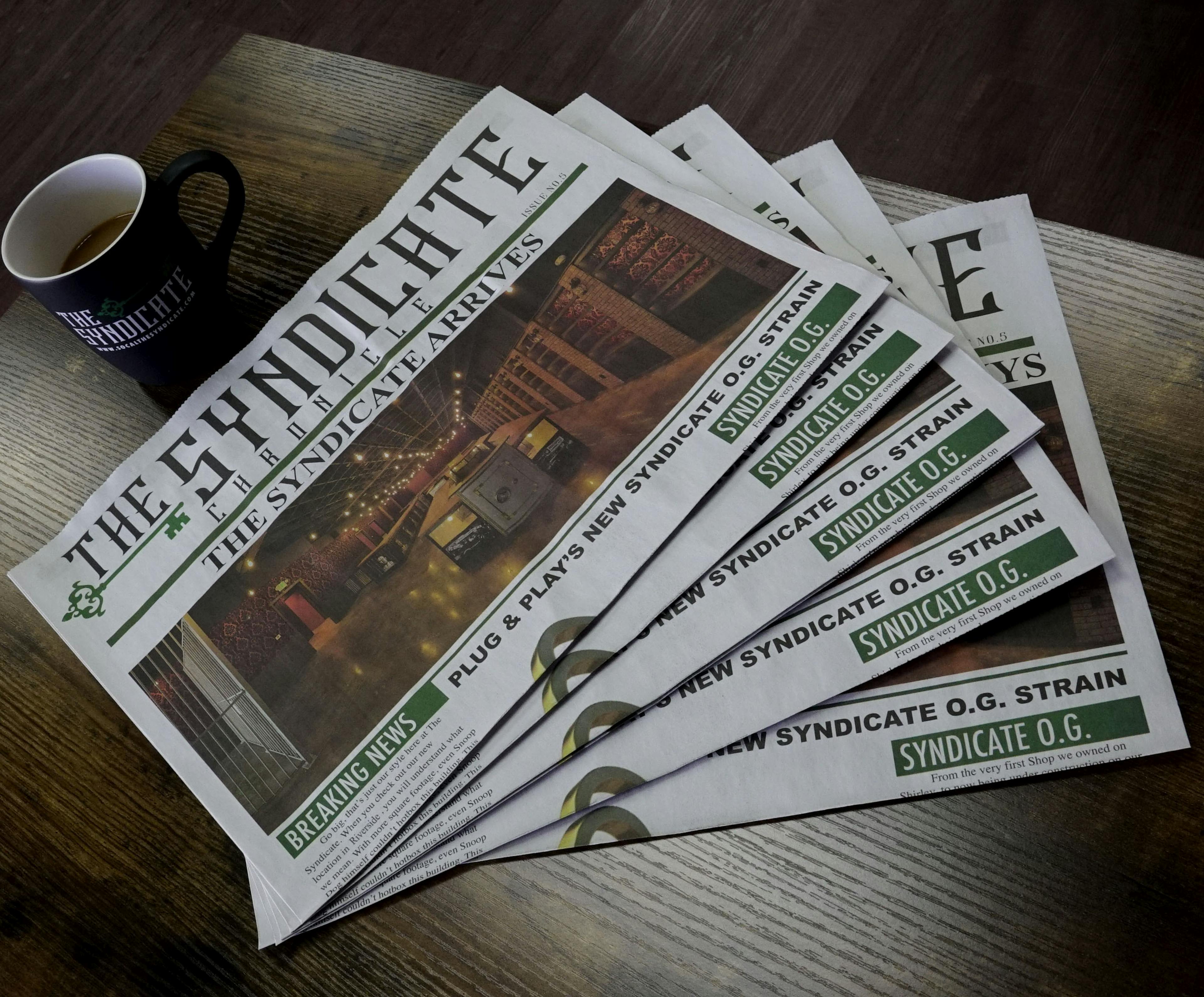 The Syndicate newspaper with a cup of coffee on a table