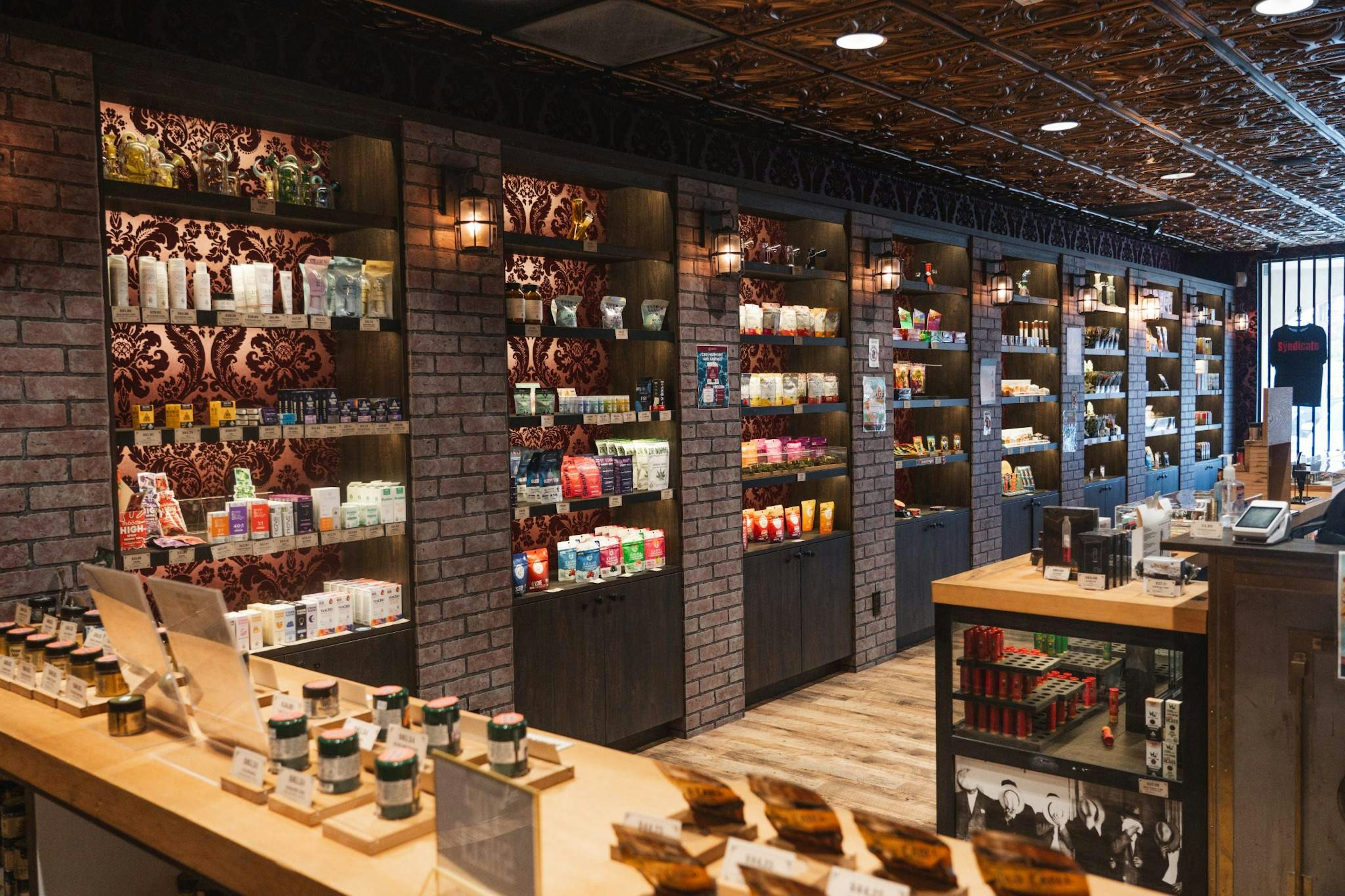 Wall-to-wall cannabis edibles, tinctures, and topicals neatly shelved at The Syndicate Moreno Valley store