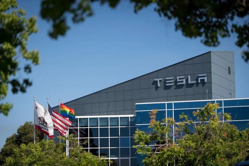 Tesla headquarters with flags flying in front of the building
