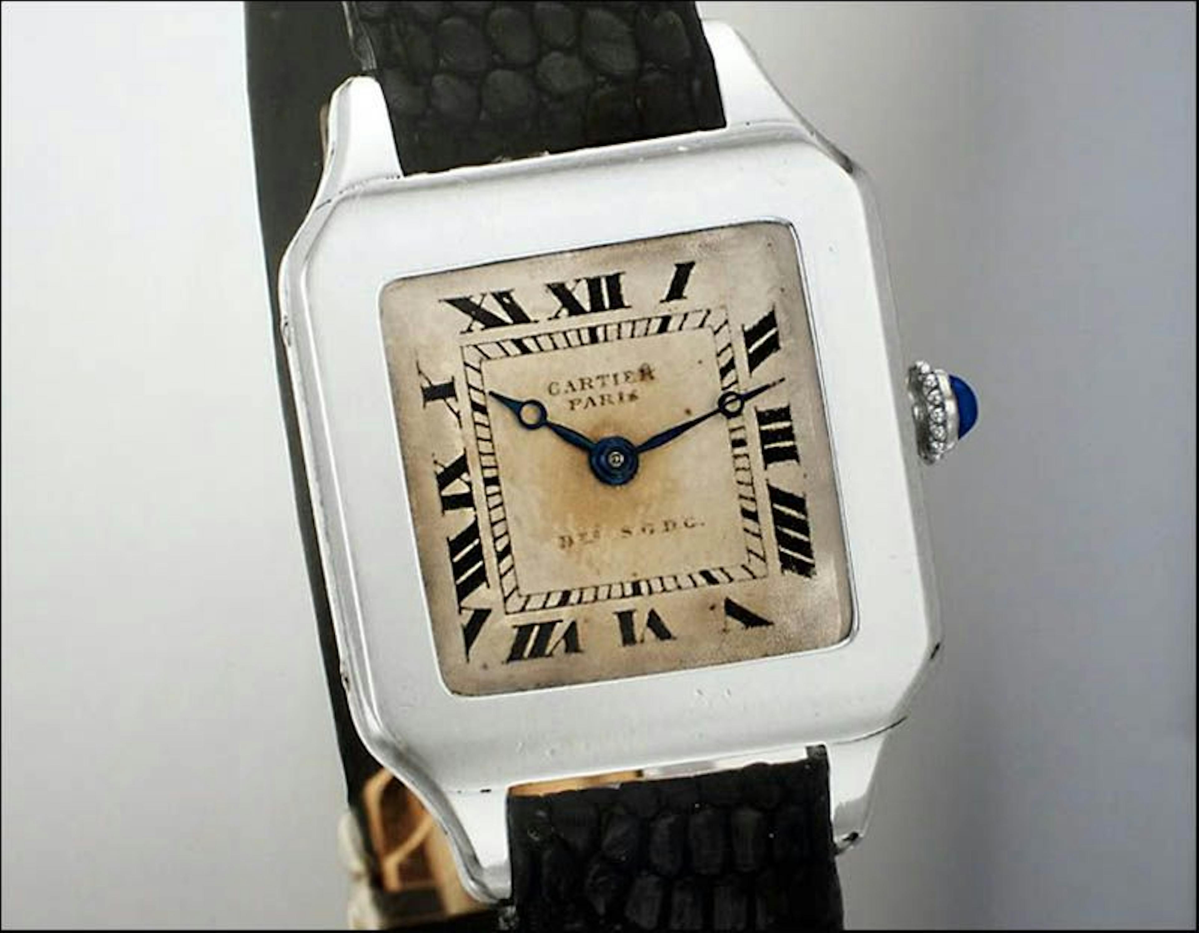 Squqare steel watch with aged white dial with Roman numerals and small Black Breguet style hands and sapphire on crown on black strap