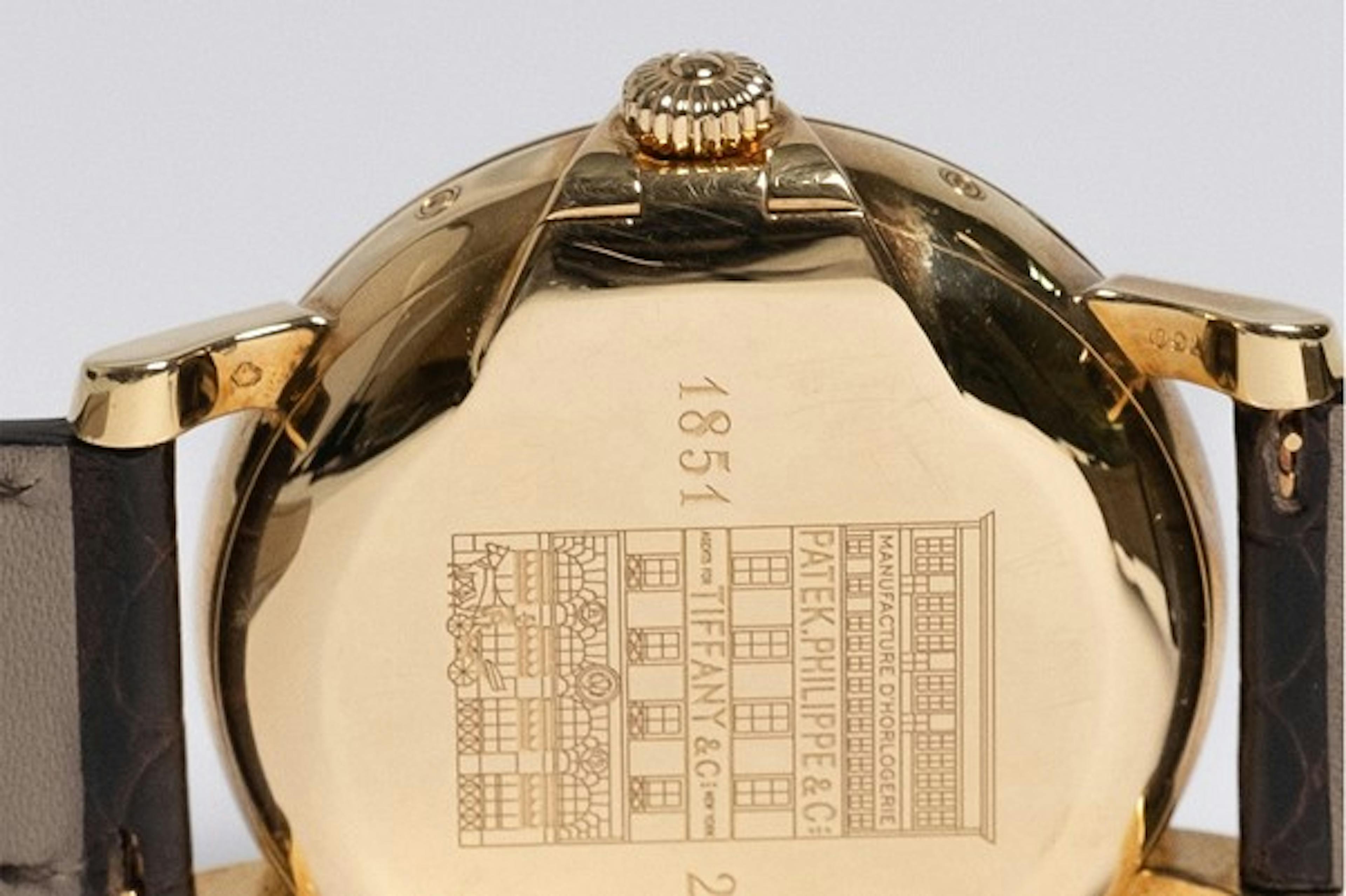 Engraved caseback of gold watch showing Tifffany and Patek Philippe storefront on T150 watch
