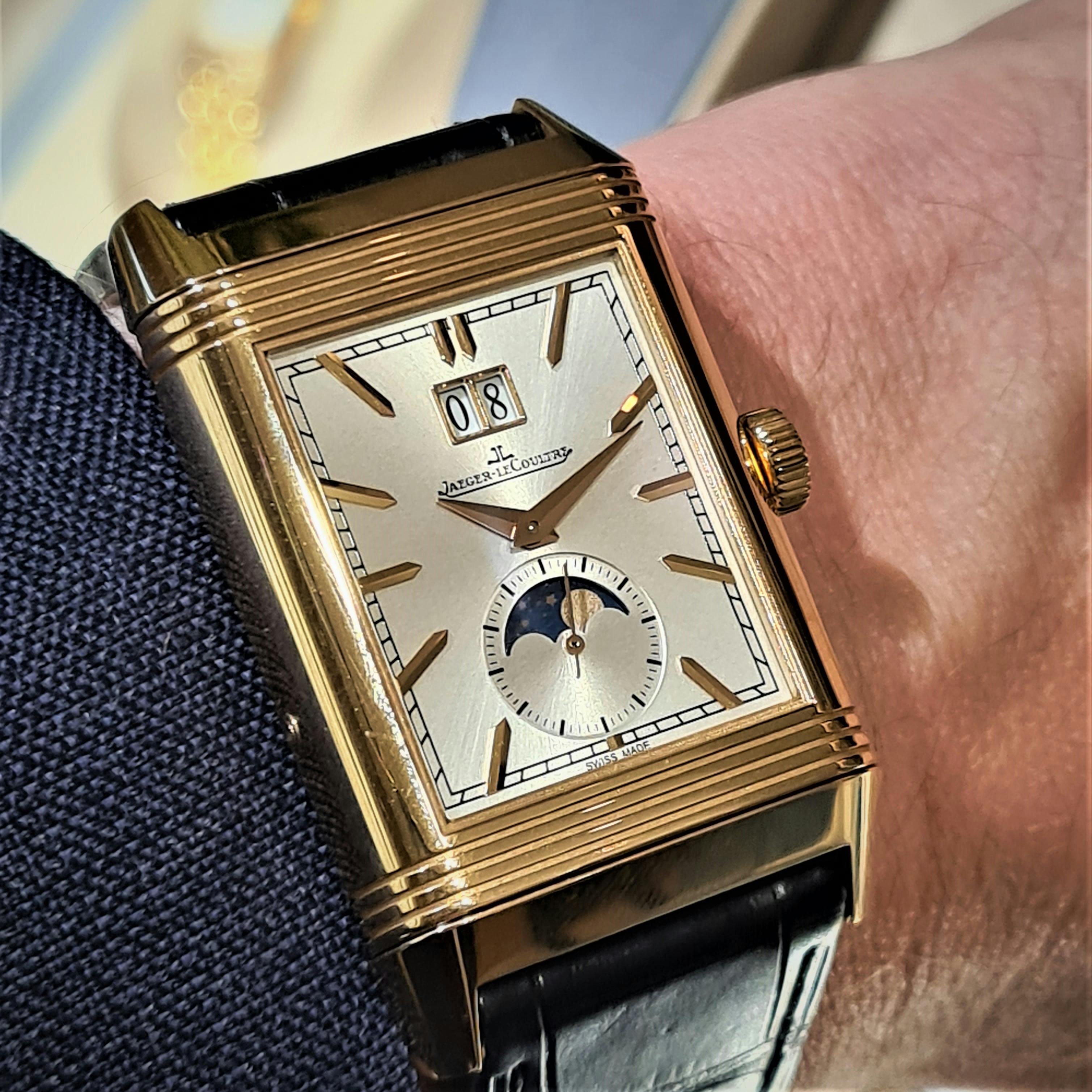 Gold rectangular wristwatch with silver dial and gold hands