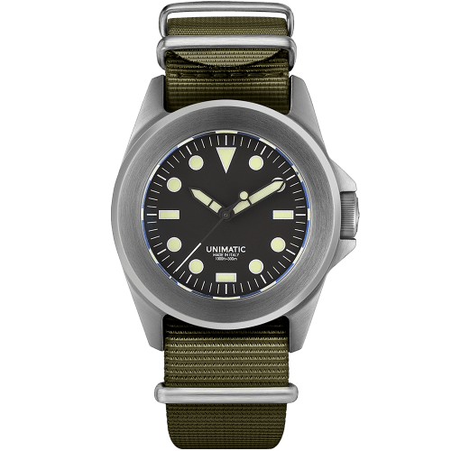 A Unimatic military style watch wtih dull grey case and bezel and black dial with large yellow luminous marketrs and hands on a green strap
