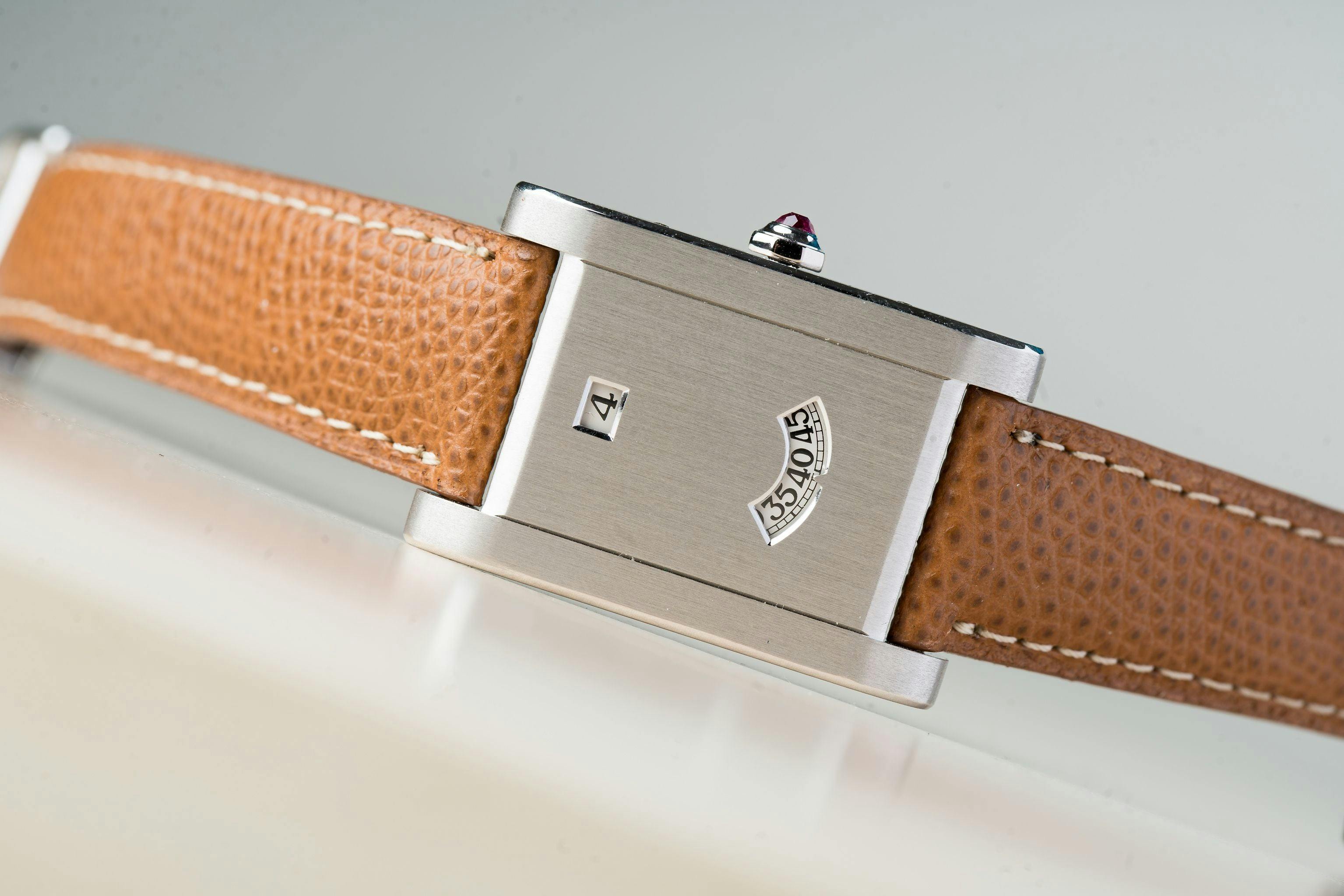 The Famous Cartier Tank A Guichet with the hours in one window and minutes in a curved window below. This is a reissue from the 1990s with the crown on the side. The original had the crown at the bottom of the case.