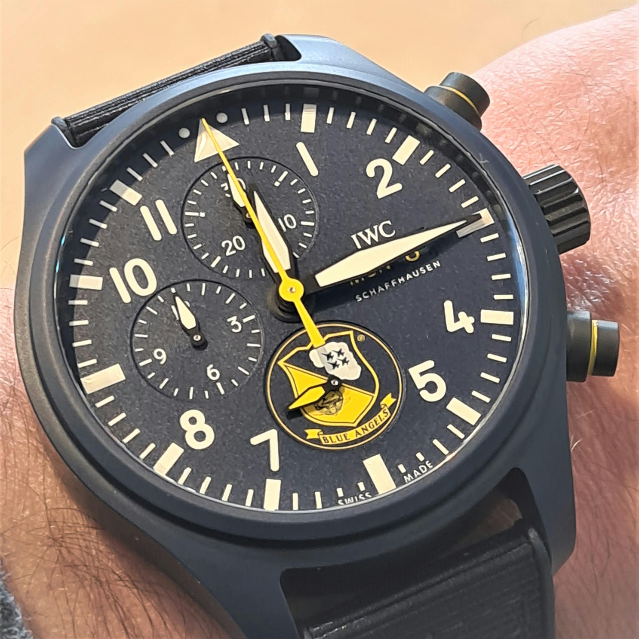 Large Dark blue chronograph watch from IWC with dark blue case dial pushers and strap white hands and indices and yellow seconds hand and Blue angels logo a the six o'clock position