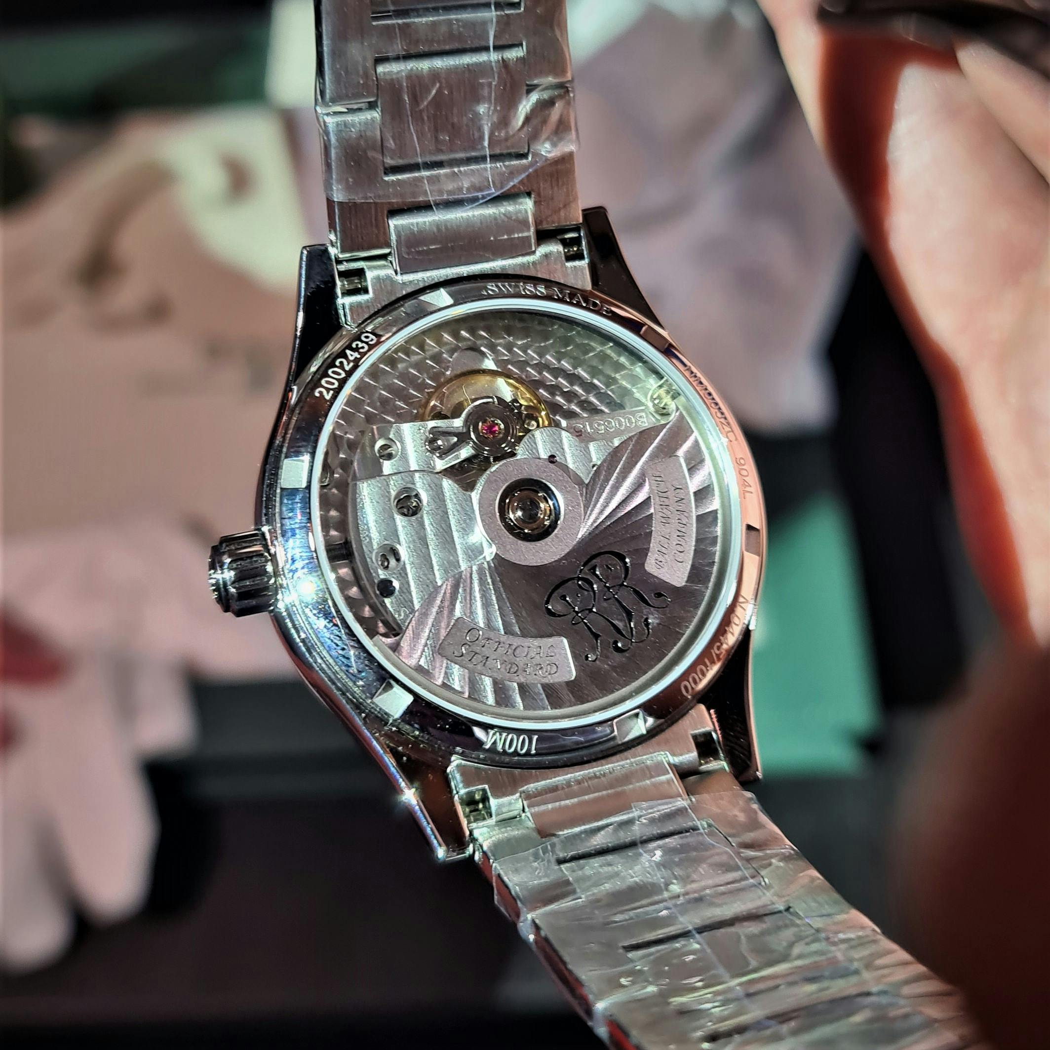 Steel silver Ball Corp. watch shown from the rear showing the engraved and decorated Rotor and movement