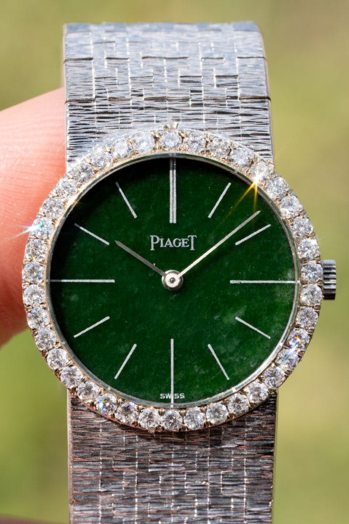 A Piaget watch from the 1960s with a green semi-precious stone dial, diamond set bezel and white gold integrated bracelet.