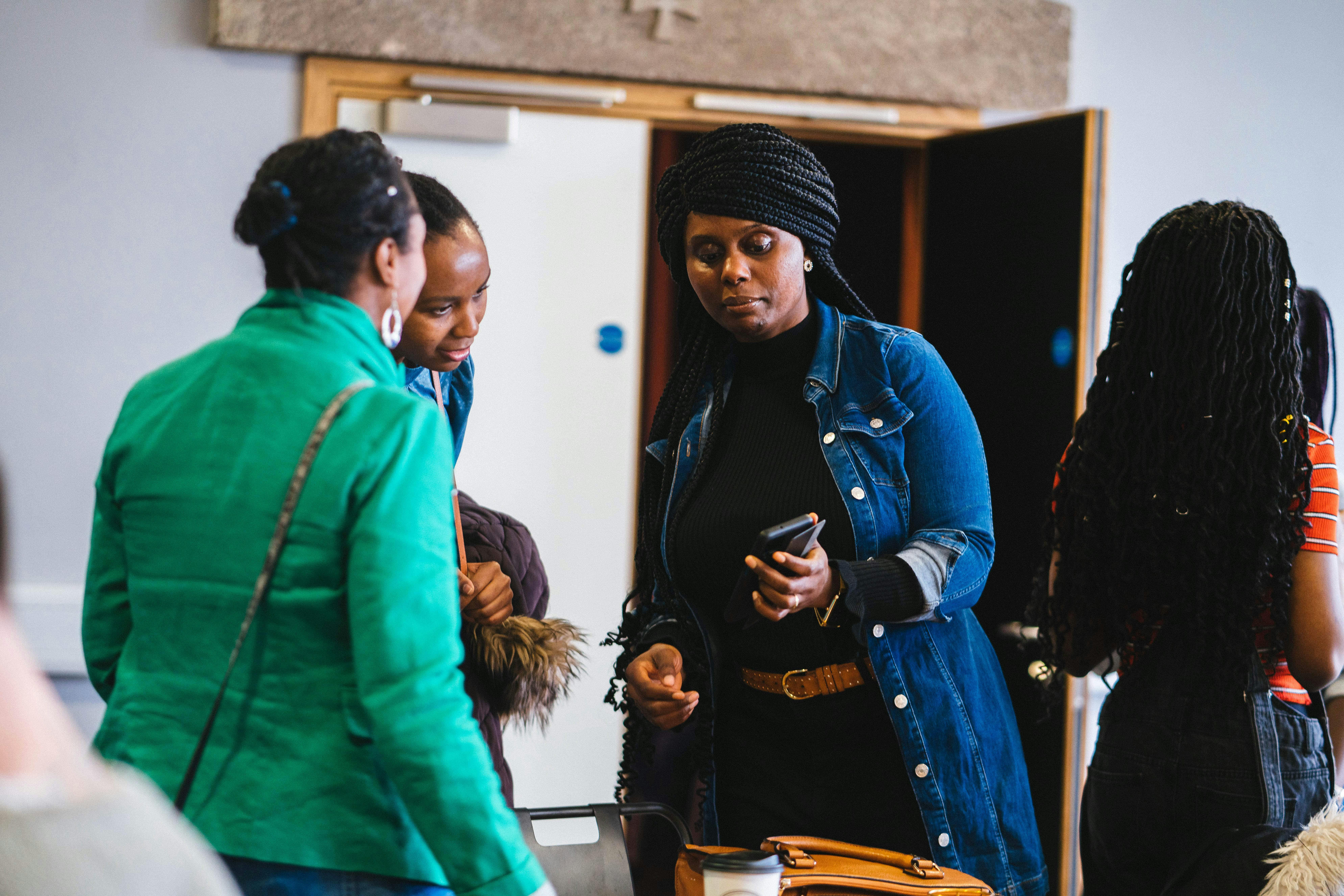 3 women looking at a phone