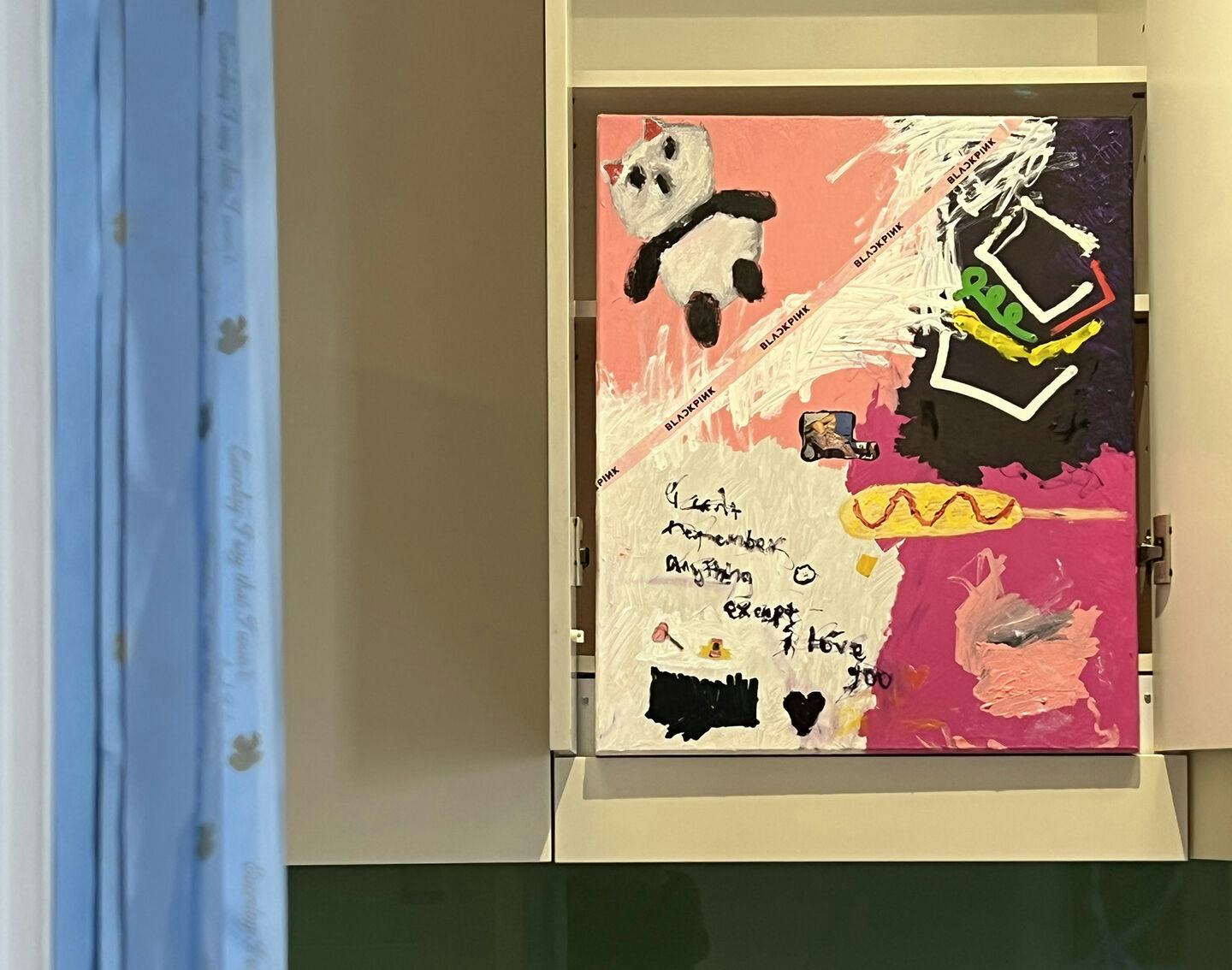 A painting by Jemi Gale with a panda in one baby pink corner opposite a hot pink corner. The text on the painting reads: 'I don't remember anything except i love yoo'. The painting is next to blue satin ribbons by Jackie de Lacy that read in cursive, ‘Everyday, I don’t’. 