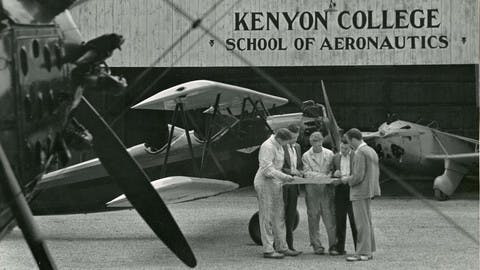 Students enrolled in Kenyon College’s School of Aeronautics gather outside the hangar to look over flight plans. 