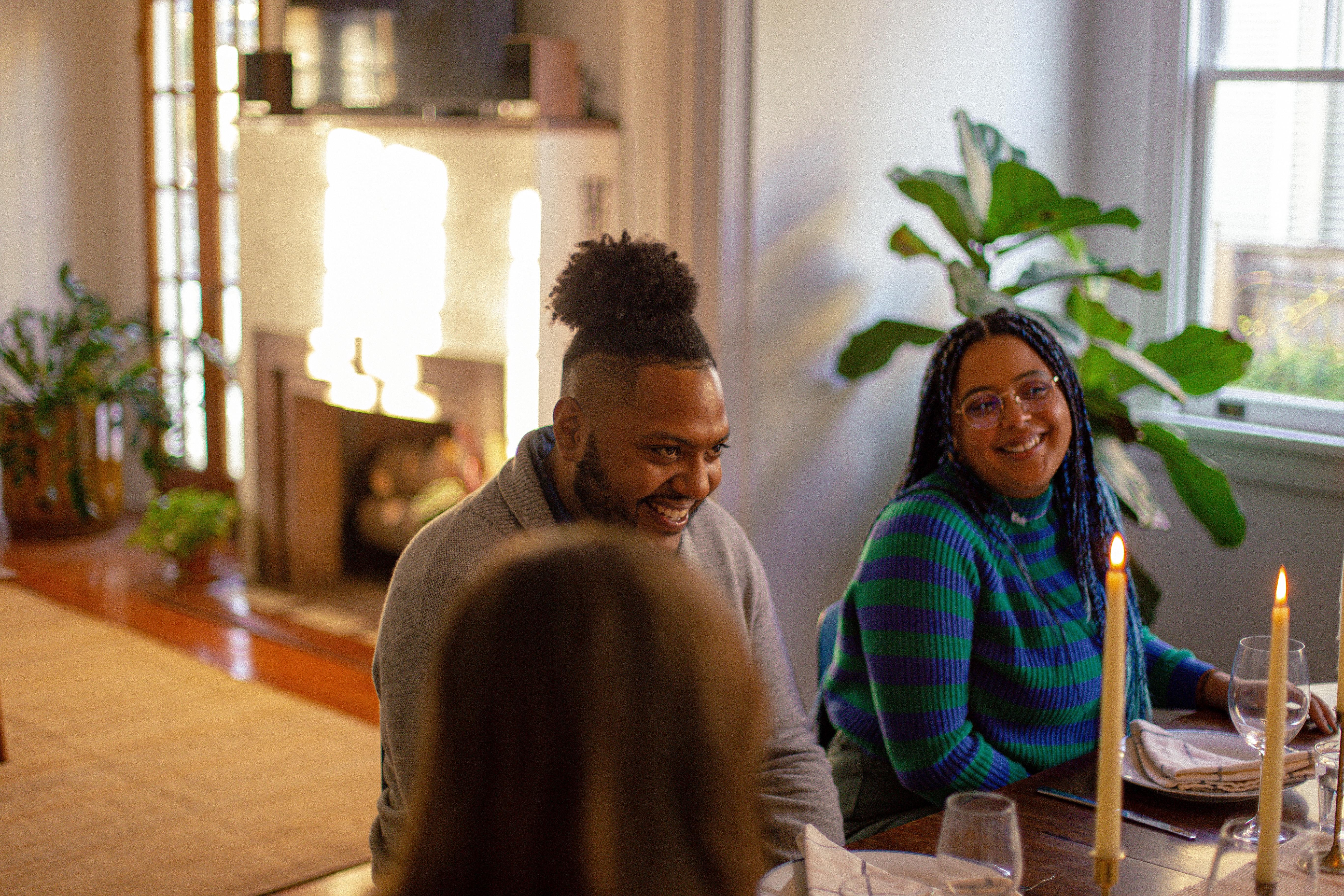 a man and woman sitting at a table with candles in front of them