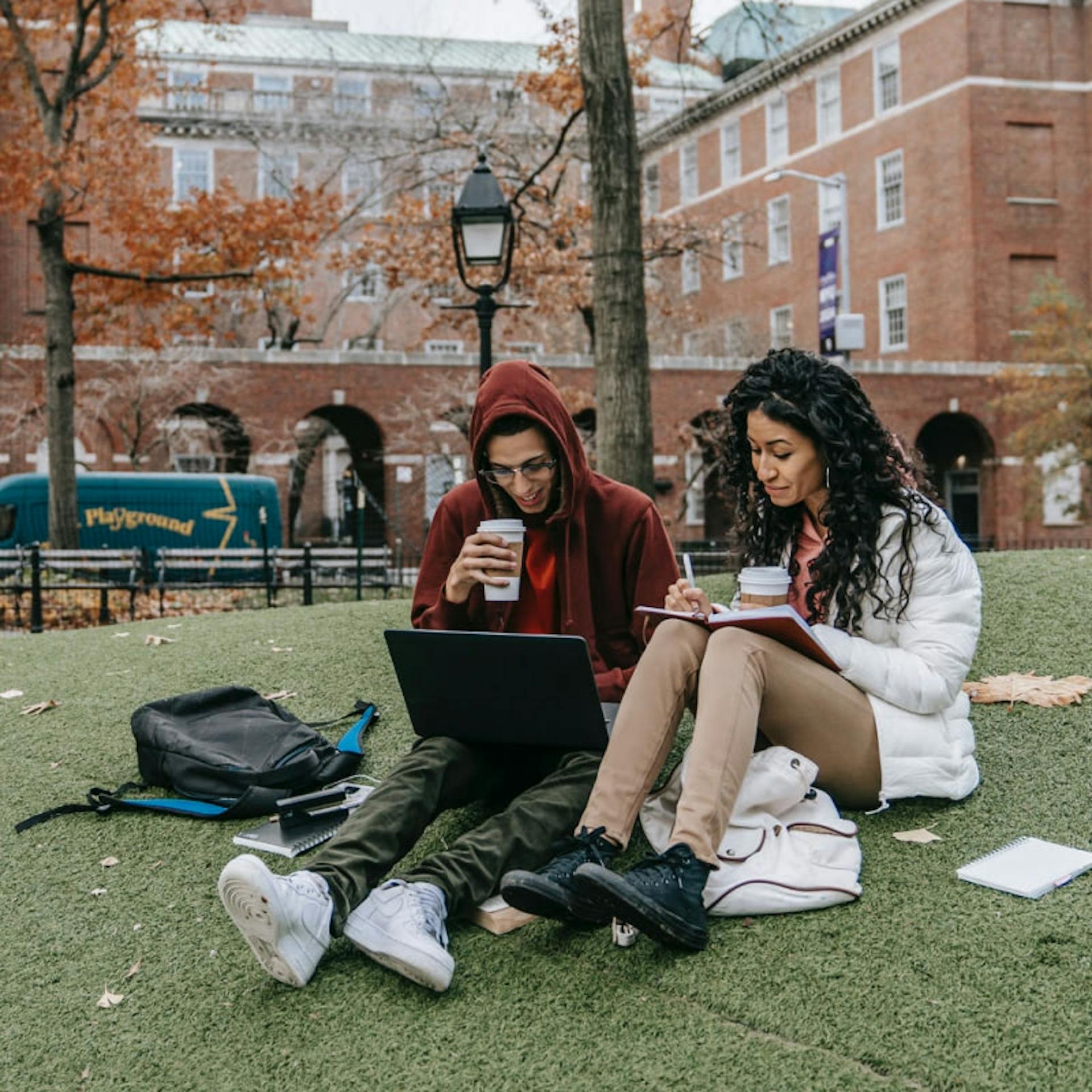 Two college students study outside.