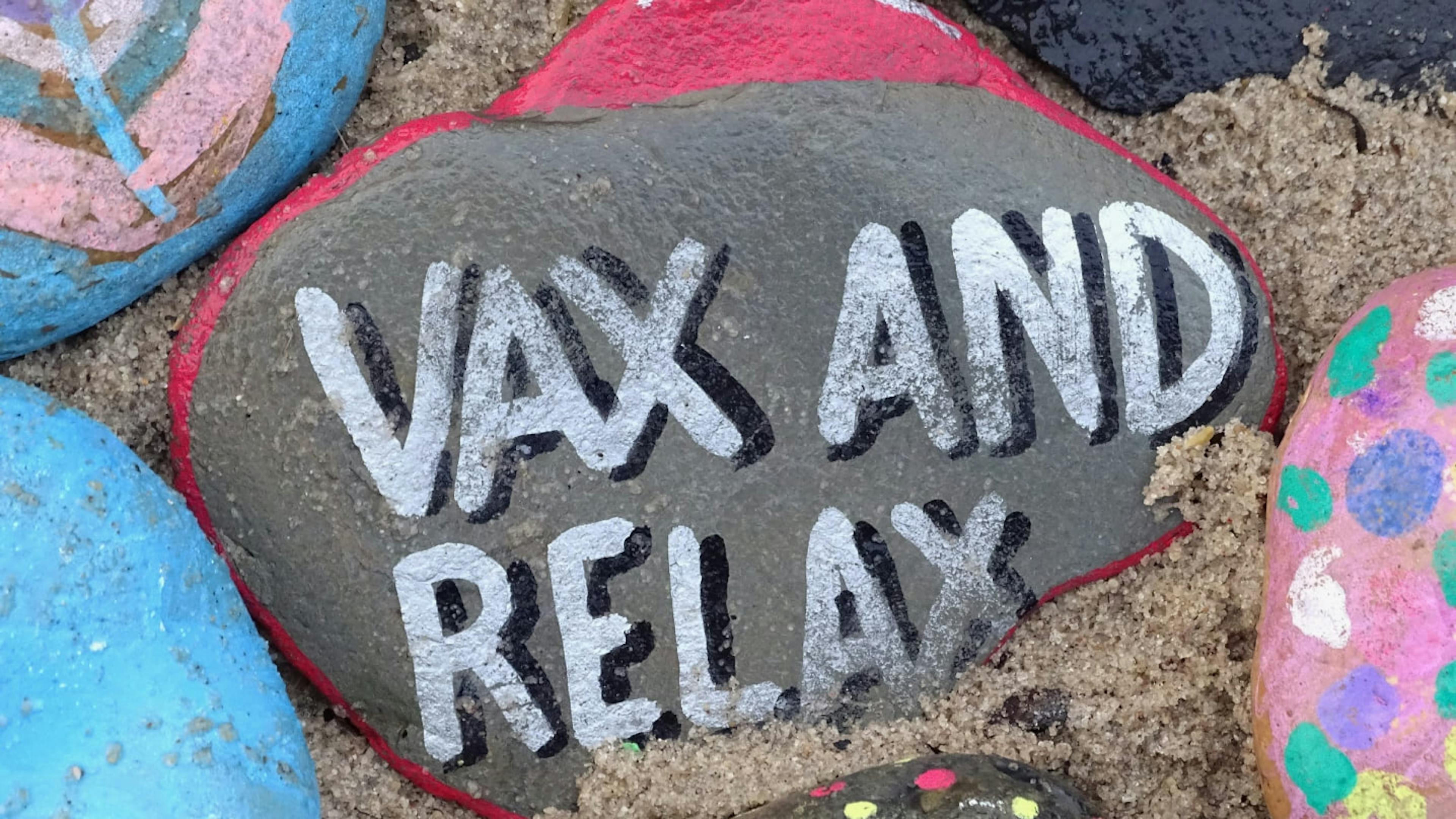 A stone with the words "vax and relax" painted across it.
