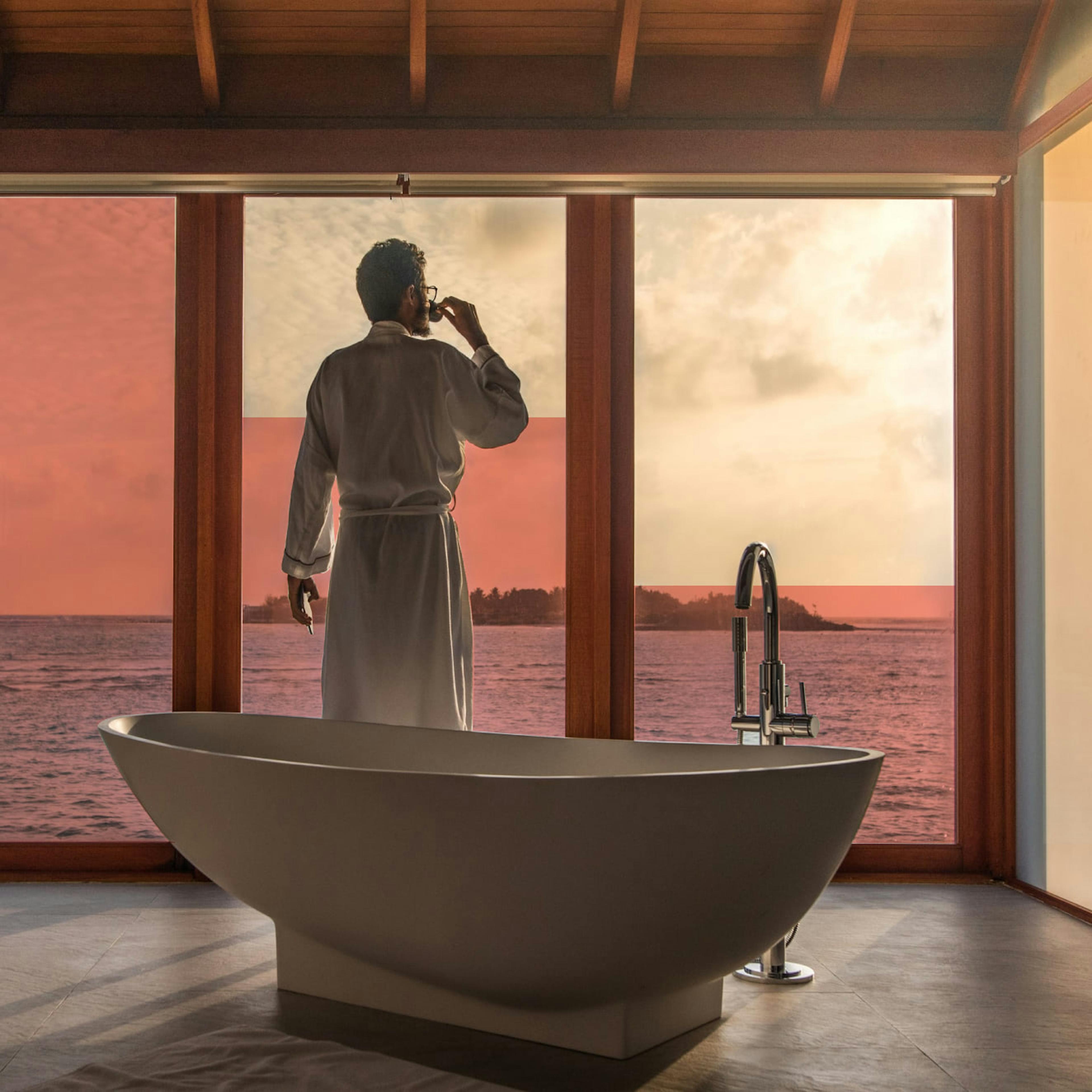 A millionaire looks out the window of his mansion.