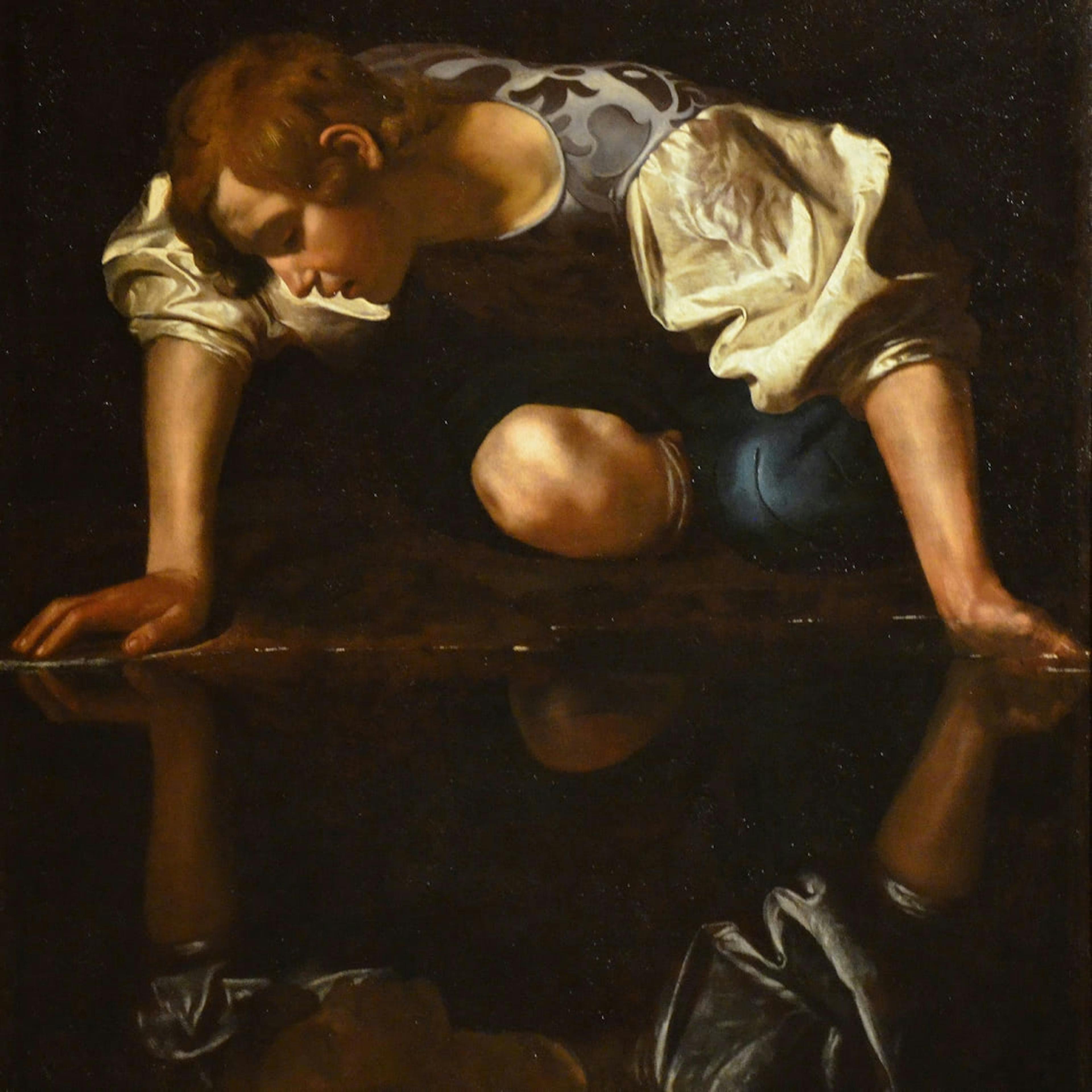 A painting by Caravaggio of Narcissus staring at his own reflection.