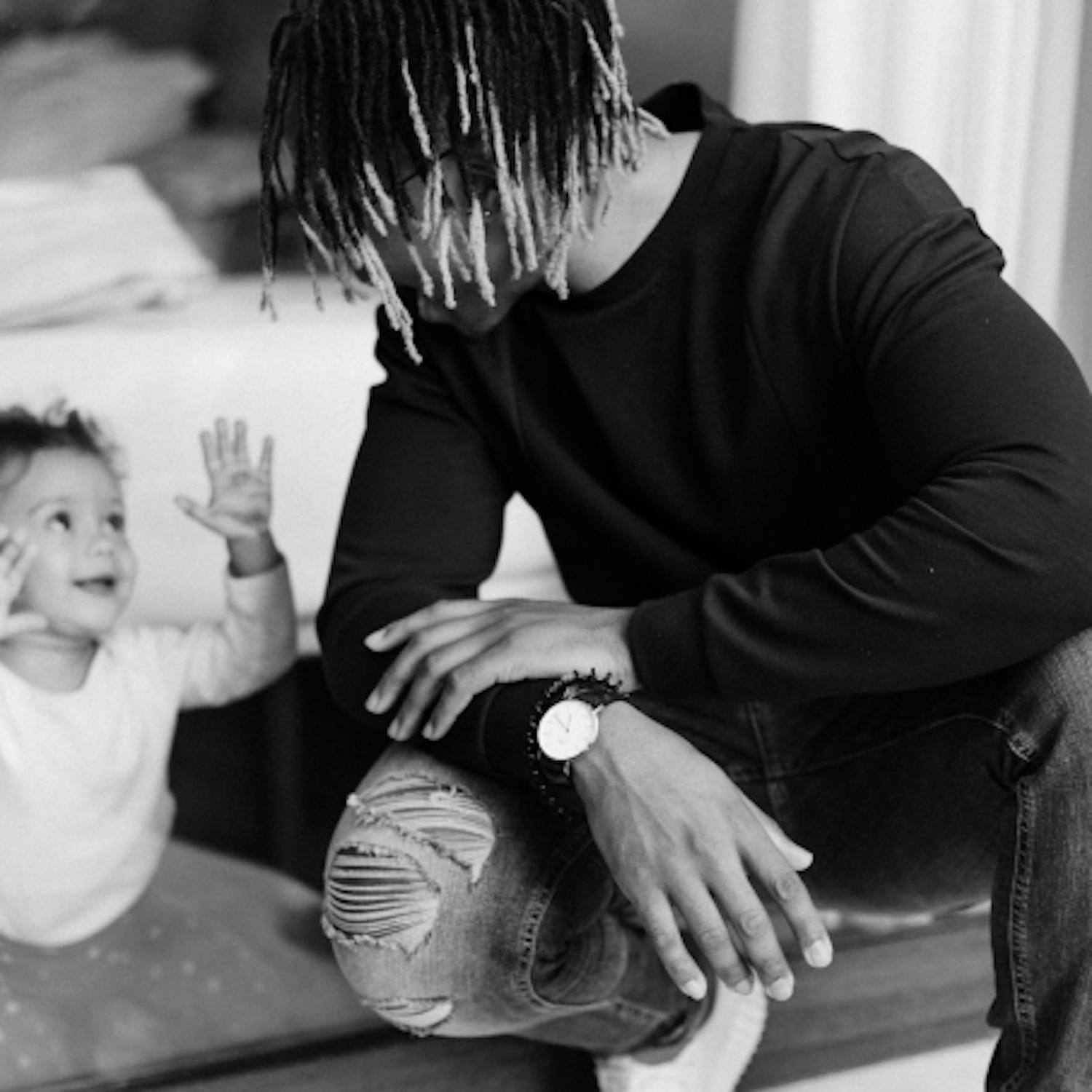 Man kneeling and looking at his toddler