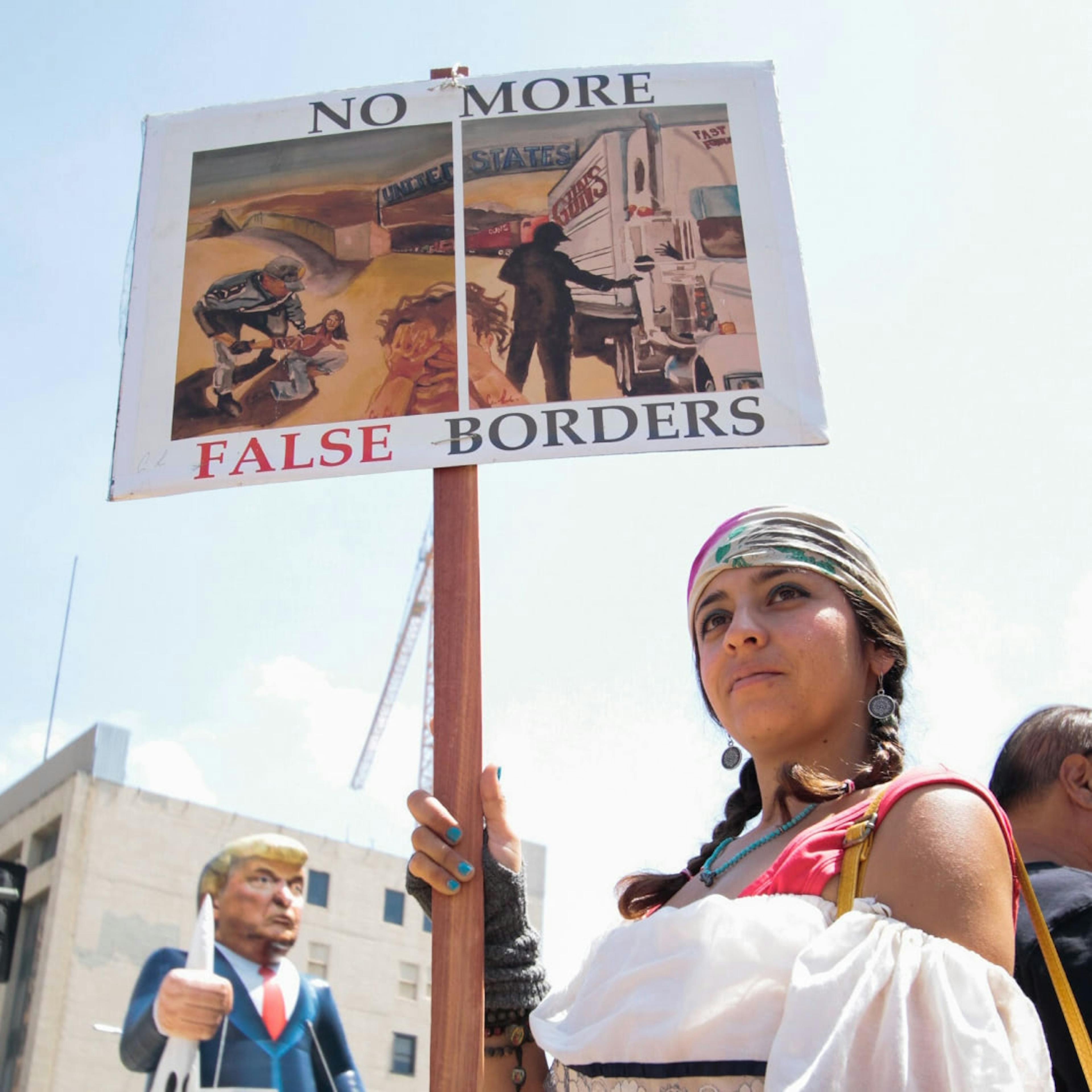 A protester holds a sign reading "No More False Borders" at a pro-immigration rally in the United States.