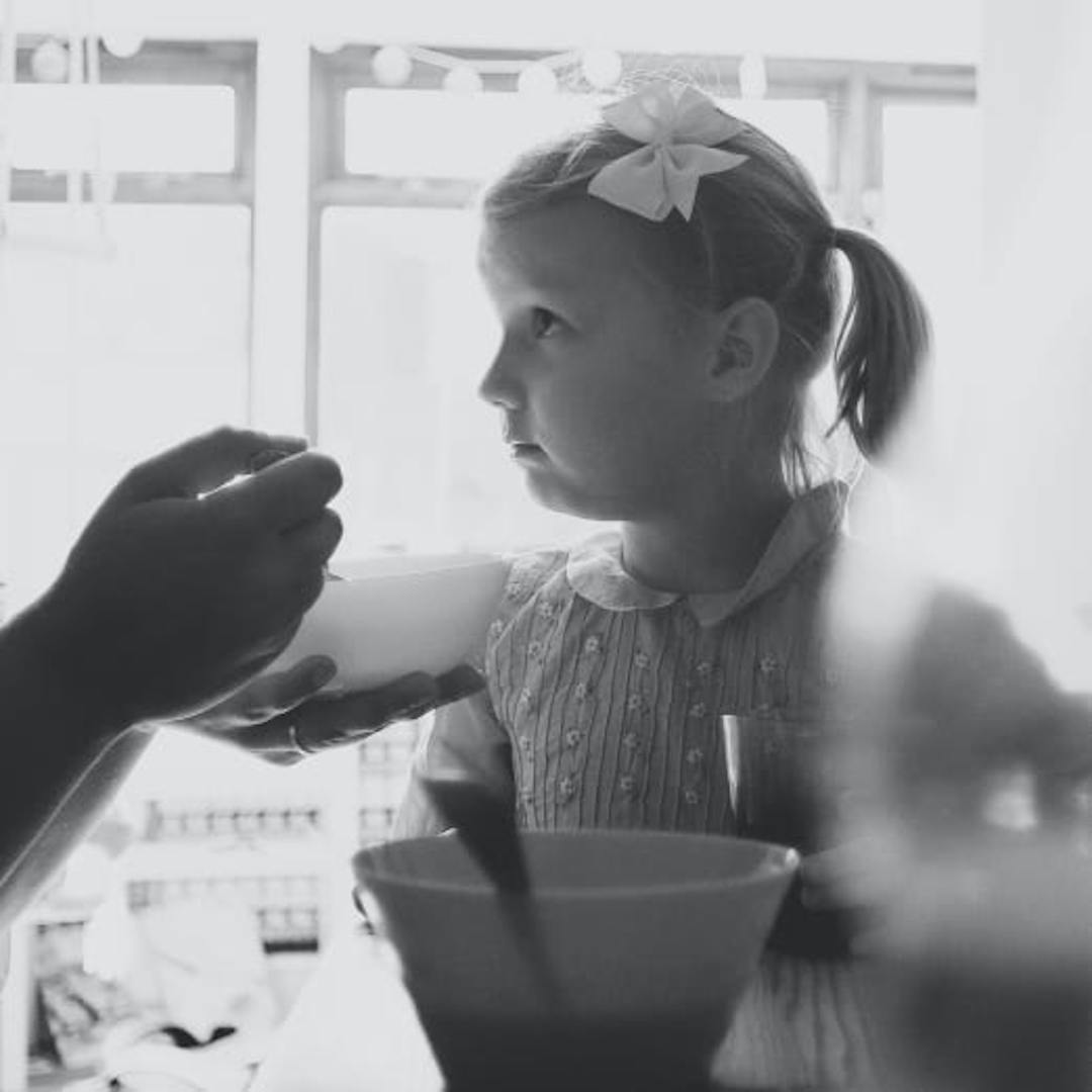 A young girl and her father eating cereal together.